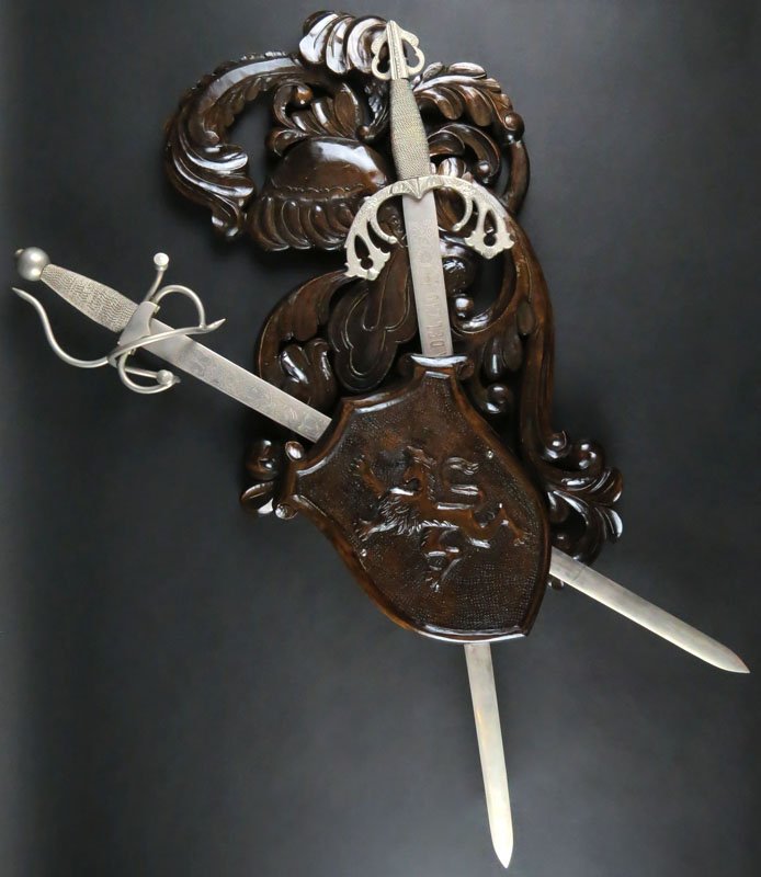 Wall Mounted Wooden Coat of Arms with Swords. One (1): Wall Mounted Wooden Coat of Arms with Swords. One (1) Sword Stamped El Cid. Good Condition. Shipping $100.00