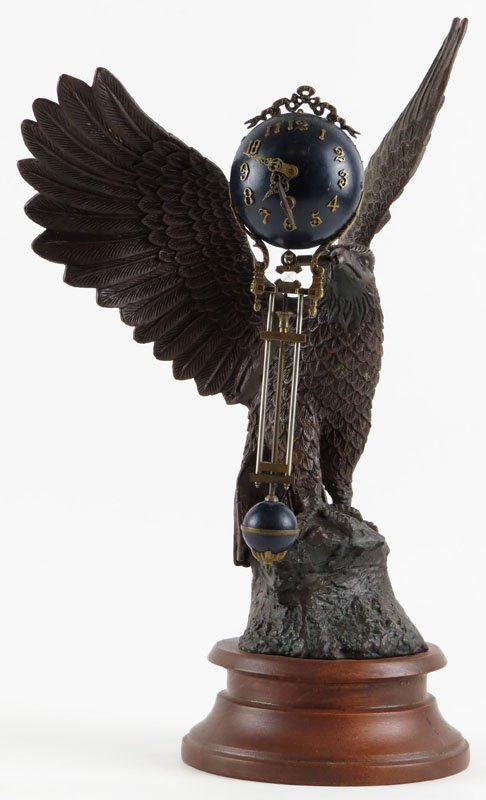 White Metal Eagle Figure Swinger Clock on Wood Base.: White Metal Eagle Figure Swinger Clock on Wood Base. Unsigned. Includes Key. Swinger Ball Unbalanced. Some Minor Wear to Finish or else Good Condition. Measures 14-1/2 Inches Tall and 10-1/2 Inches Wi