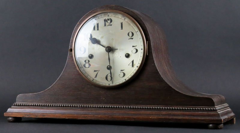 German Wooden Hump Back Mantle Clock with Key and: German Wooden Hump Back Mantle Clock with Key and Pendulum. Movement Signed Oufa Germany. Westminster Chimes. Minor Chips to Case or else Good Condition. Measures 11-3/4 Inches Tall and 21-1/2 Inches 