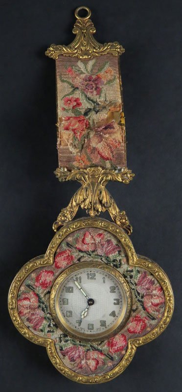 Wall Hanging Clock. Unsigned. Damage to Material. Clock: Wall Hanging Clock. Unsigned. Damage to Material. Clock Running. Please Examine This Lot carefully Before Bidding. Measures 10 Inches Long and 4 Inches Wide. Shipping $20.00