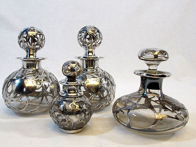 4 Silver OverlayDresser Bottles: 4" to 6 1/2". Four Sterling silver overlay bottles. A good clean group with excellent overlay.
