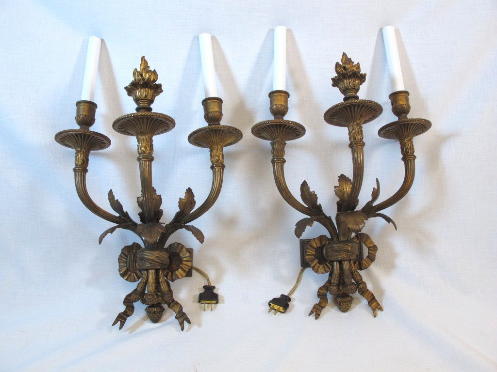 Pair E. F. Caldwell Bronze Sconces: Pair of E. F. Caldwell three-arm gilt bronze light wall sconces. Signed C in diamond (well known Caldwell mark). Detailed with foliate, ribbon, and flame castings. E. F. Caldwell & Co. was one of Amer