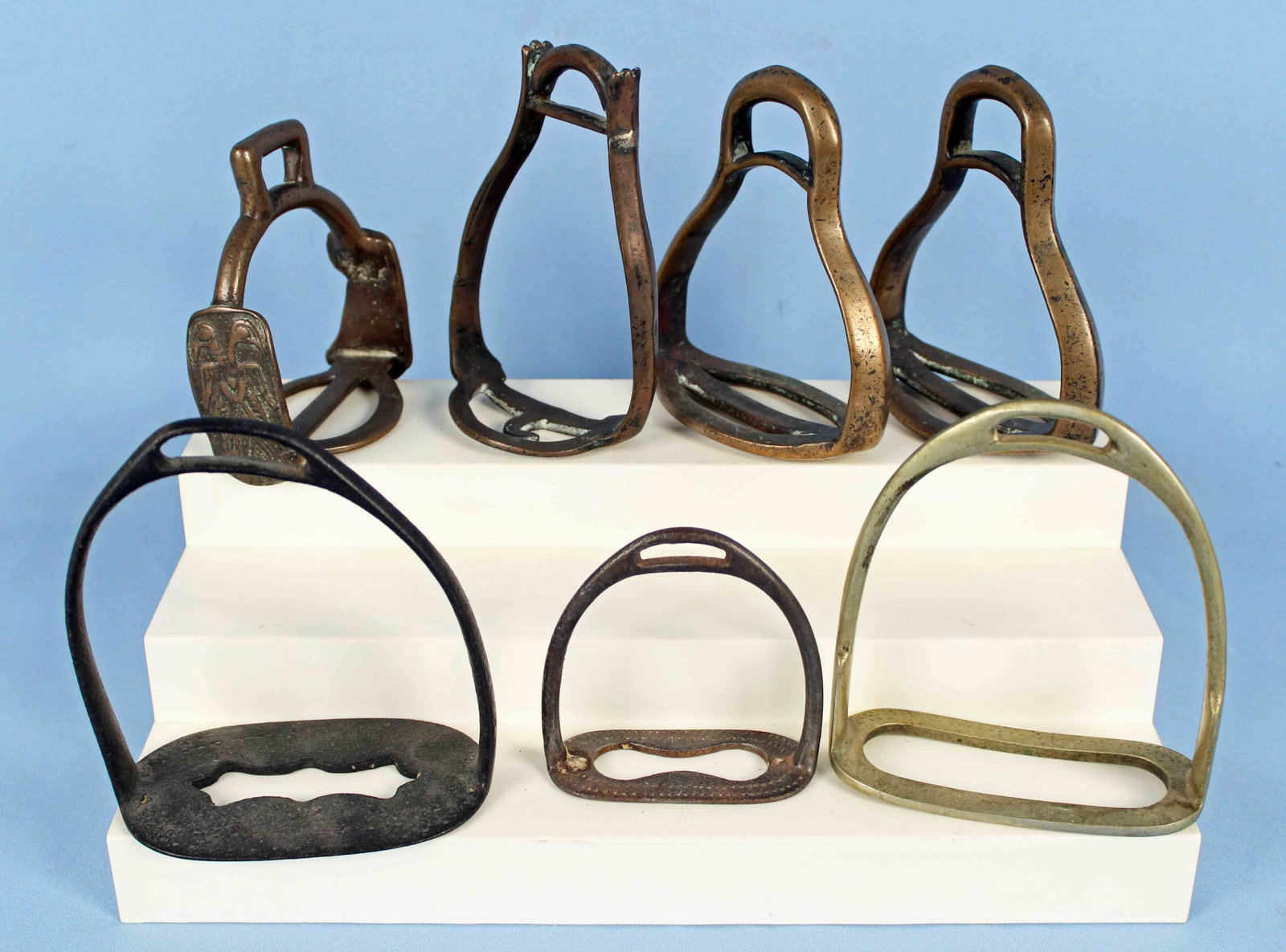 Seven Brass or Cast Iron Stirrups: Seven Brass or Cast Iron Stirrups. (2) Set includes one pair of matching brass stirrups. Measuring 5 1/2" high x 4 3/4" wide x 2 1/2" deep. (3) Odd brass stirrups. (2) Cast iron stirrups. Most of the 