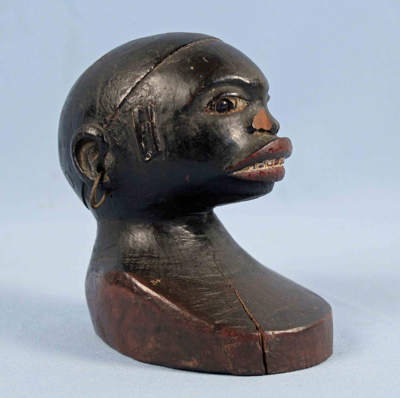 19th C. African American Carved Folk Art Bust: 19th C. South Carolina African American Carved Wooden Folk Art Bust. Polychromed red lips, white teeth and black hair and skin. Bust has brass earrings, glass eye and measures 5.25" High X 3" Wide X 4