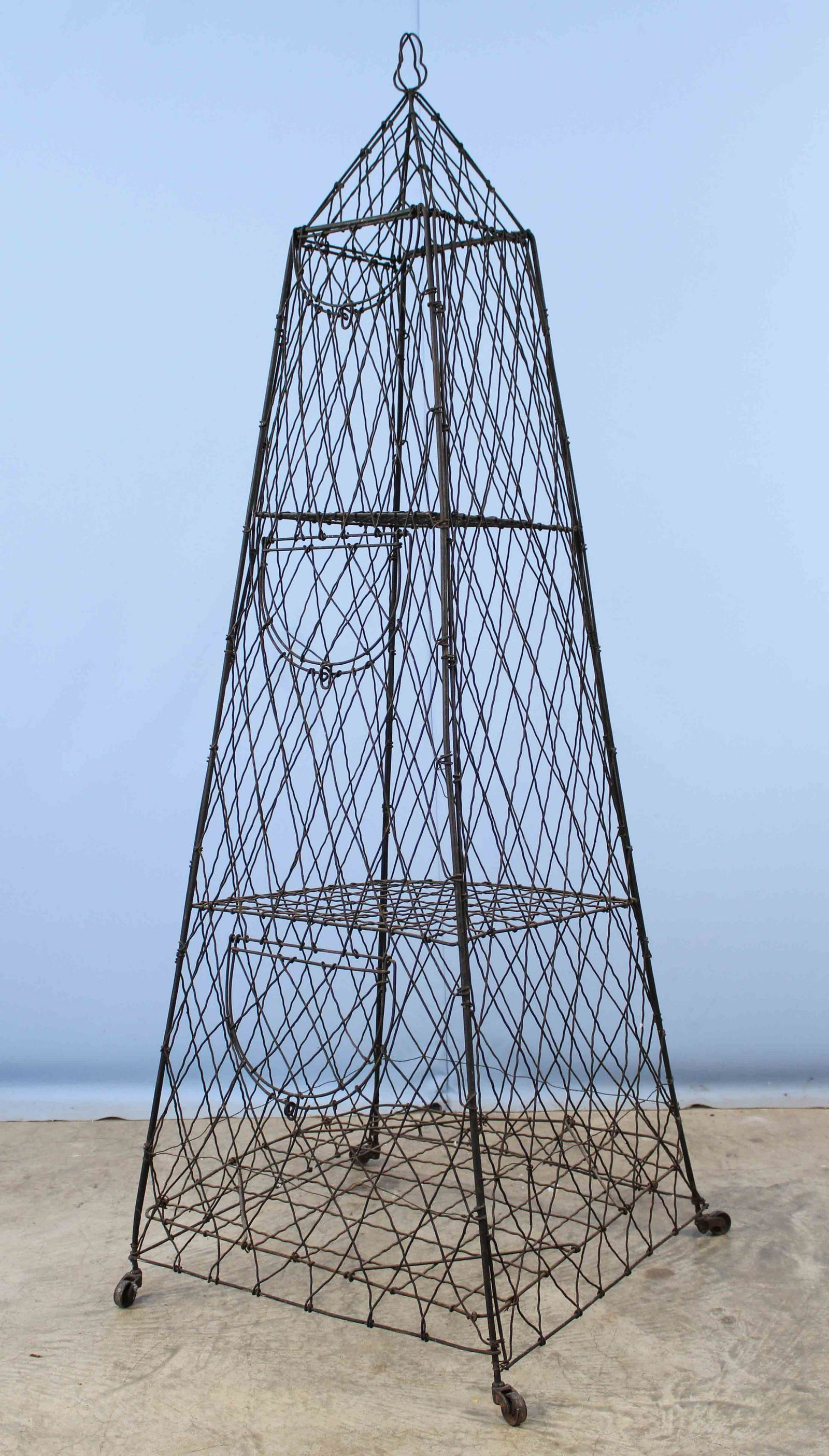 19th/20th C. Woven Wire Obelisk Store Display: Late 19th or Early 20th C. Woven Wire Obelisk Store Display Etagere. Divided into three compartments with fold-up doors. Measures 58" high X 19 3/4" square base. Condition - Display is in good conditi