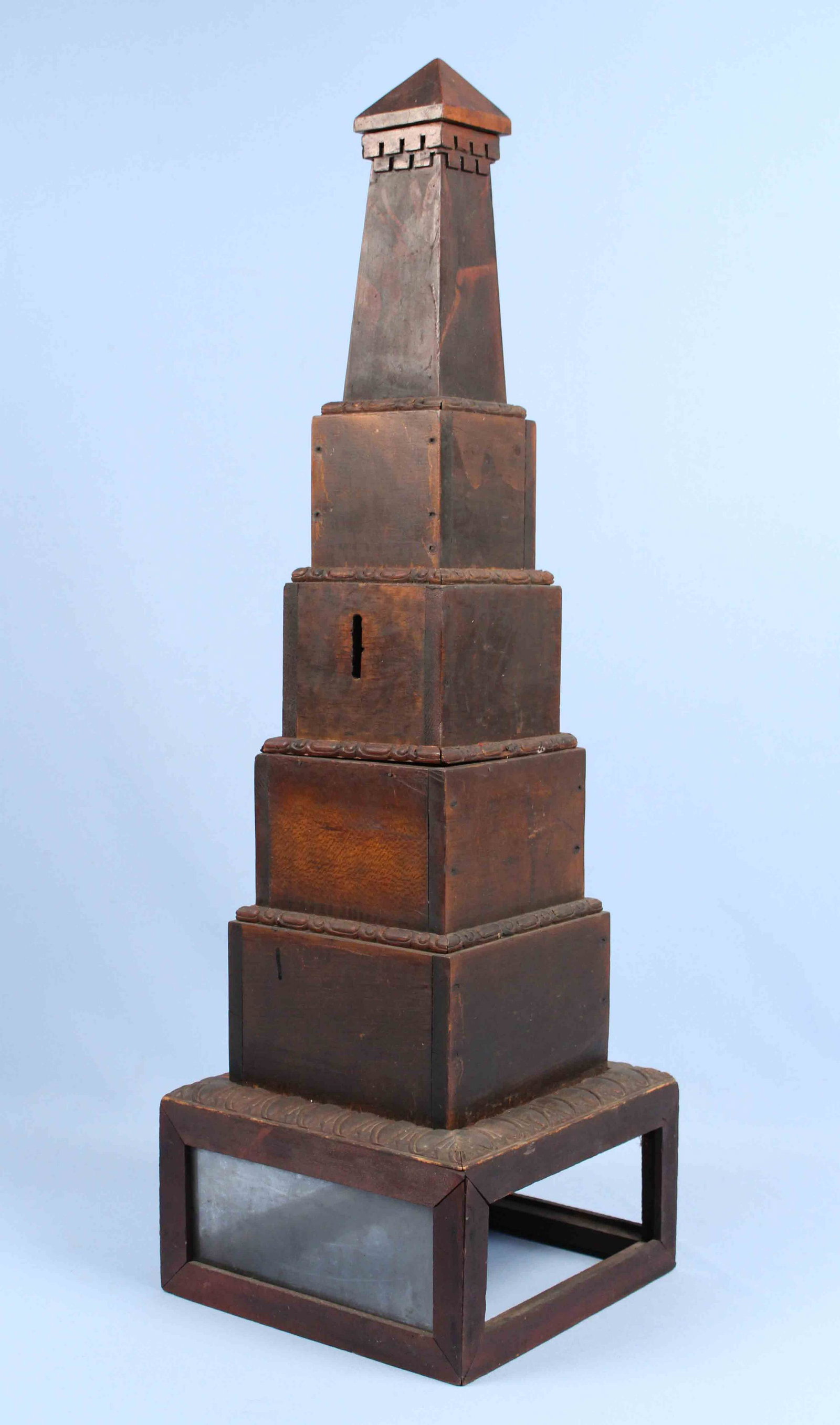 Folk or Tramp Art Monument Vote Box: A Folk or Tramp Art Wooden Monument Voting Box. Has 1 5/8" slot to insert paper ballots. Measures 32" H. X 10" Sq. at base. Purchased in New York City. Condition - Overall very solid condition. Missin