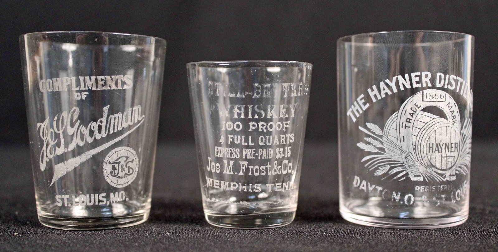 3 Antique Whiskey Shot Glasses Memphis Etc.: Three Antique Whiskey Shot Glasses Memphis Etc. (1) "Spill Better Whiskey" 100 Proof Whiskey, Four Full Quarts, Express Pre-Paid $3.15., Joe M. Frost and Co., Memphis Tenn. 2 1/8" High. (1) Goodman, S