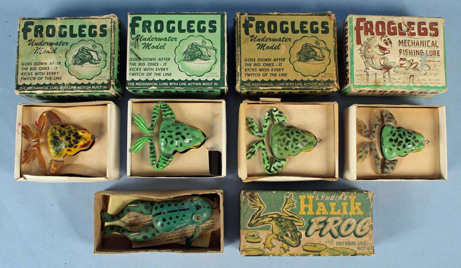Five Mid 20th C. Frog Fishing Lures w/ Boxes: Five Mid 20th C. Frog Fishing Lures w/ Boxes. (2) Froglegs #204 mechanical lure, Jenson Distributing Co., Waco, Texas. (1) Froglegs natural green treble sinker mechanical lure. (1) Froglegs #202 mecha