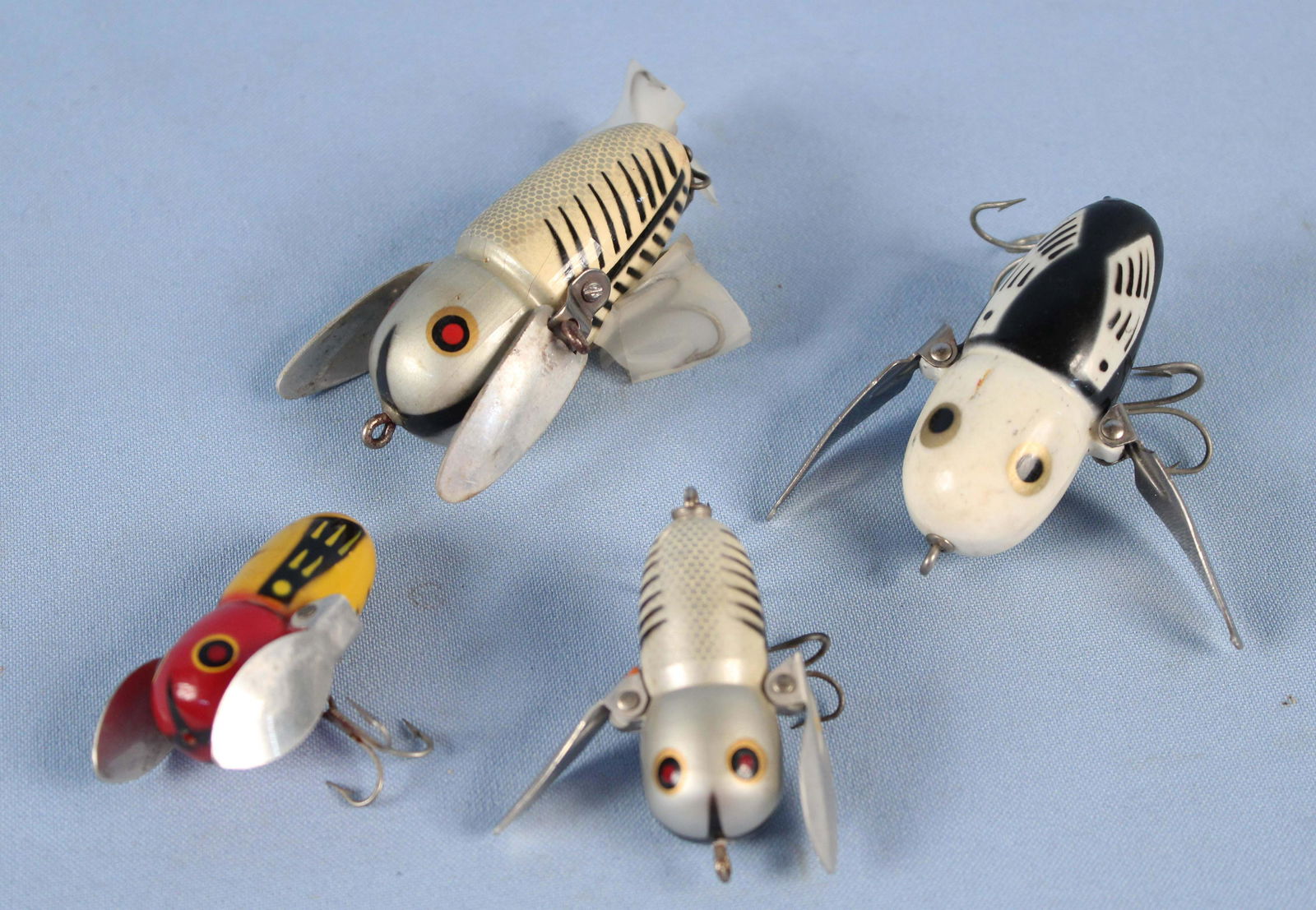 Four Heddon Crazy Crawler Fishing Lures: Four Heddon Crazy Crawler Fishing Lures. (1) Yellow red and black Tiny Crazy Crawler, missing rear hook body measures approx 1 3/4" Long. (1) Silver black and white Crawler measures 2 3/8" Long. (1) .