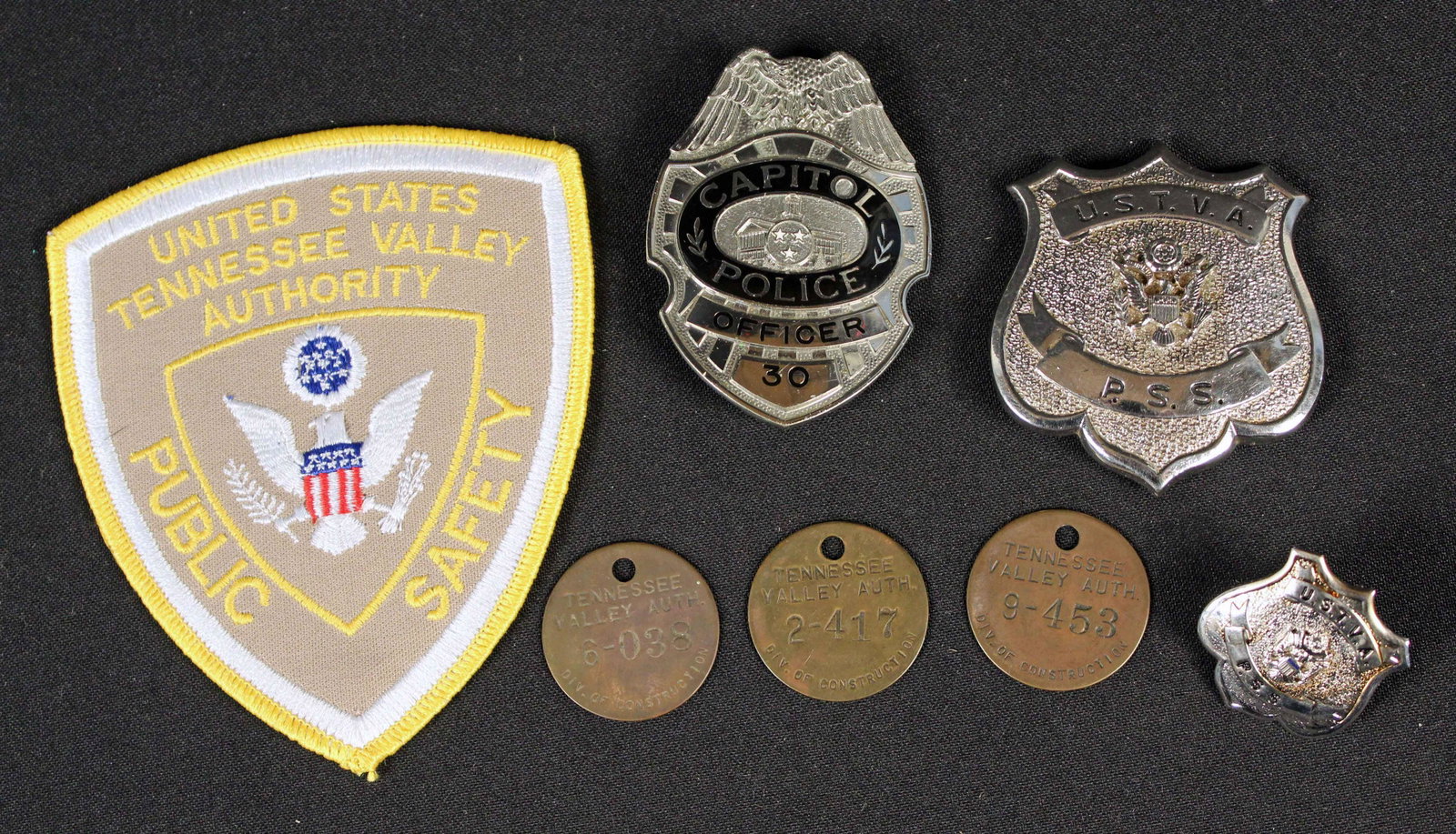 Tennessee Police Badge & T.V.A Items: Tennessee Police Badge & T.V.A Items. (1) Tennessee Capitol Police Officer badge. (1) United States Tennessee Valley Authority Public Safety patch (2) U.S.T.V.A. P.S.S. badges. One badge is smaller. (