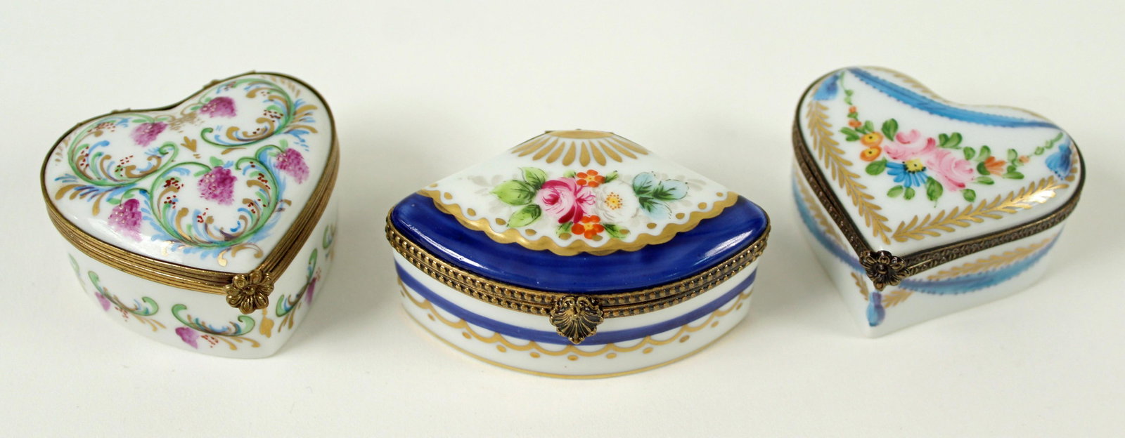 Three Peint Main Limoges France Porcelain Boxes: Three Peint Main Limoges Hand Painted France Porcelain Trinket Boxes. (2) Heart shaped boxes measure Approx. 2" X 2" and Approx. 1 1/8" H. (1) Fan shaped box marked Limoges France, Peint Main, Chamart