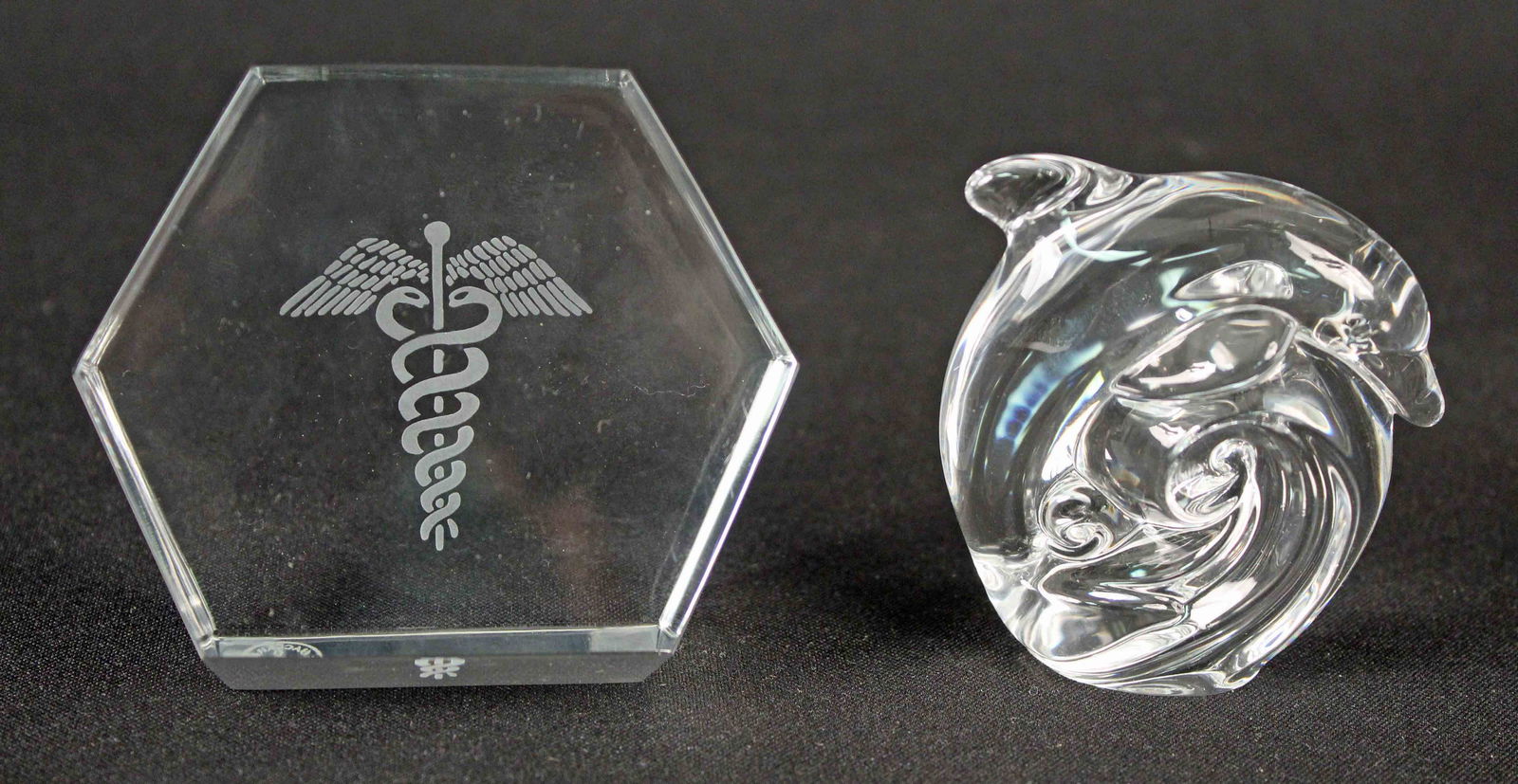 Baccarat Caduceus & Steuben Dolphin Paperweights: Baccarat Caduceus & Steuben Dolphin Paperweights. (1) Baccarat Doctor's paperweight measures 3 3/8" X 1 3/8" and is signed. (1) Steuben Dolphin riding a wave paperweight measures 2 1/2" High and is si
