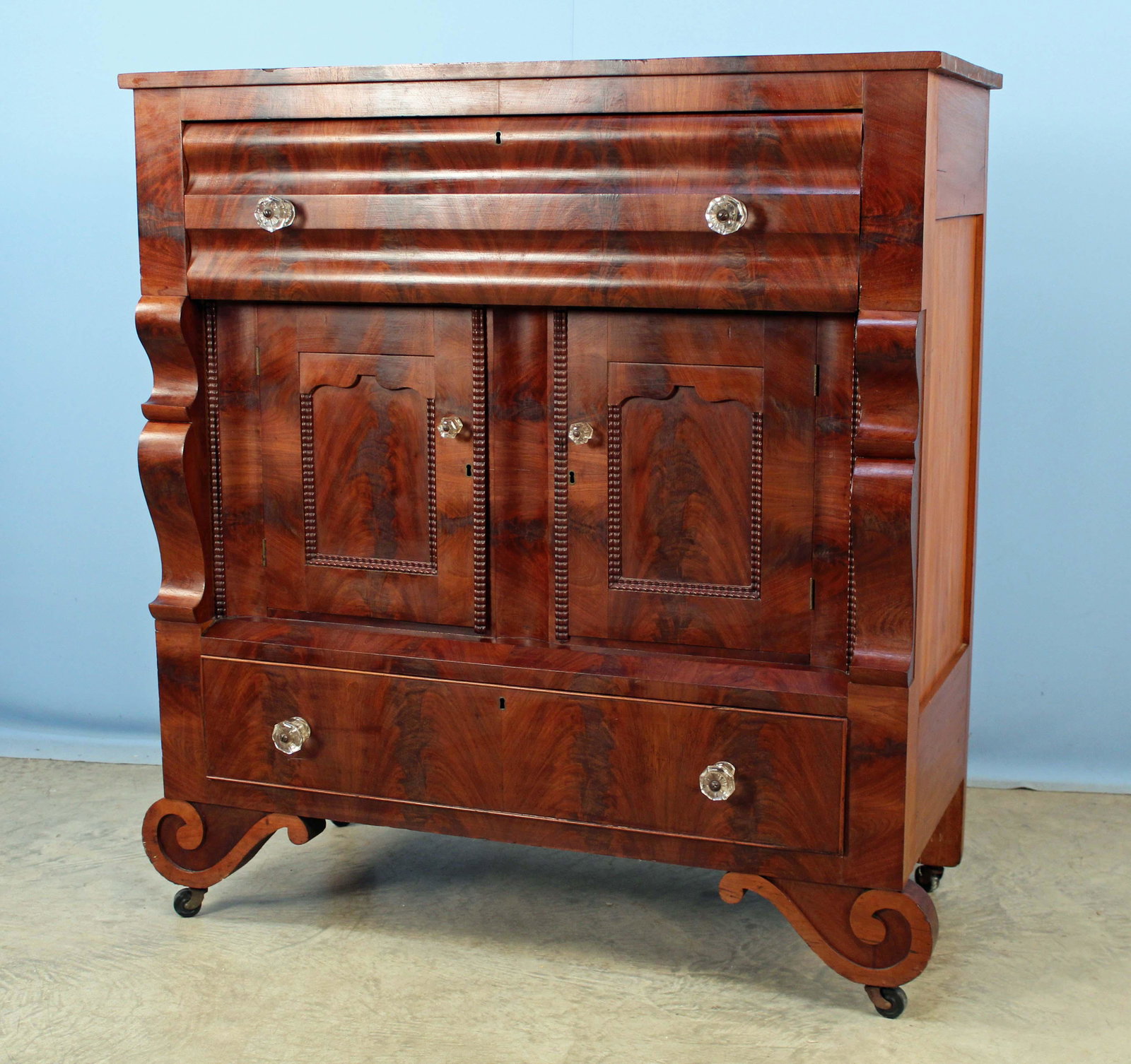 American Empire Mahogany Press C. 1830: American Empire Mahogany Press Circa 1830. This cabinet has chest and press features. The piece has large upper drawer above two blind recessed doors above bottom drawer. Has four pressed glass drawer