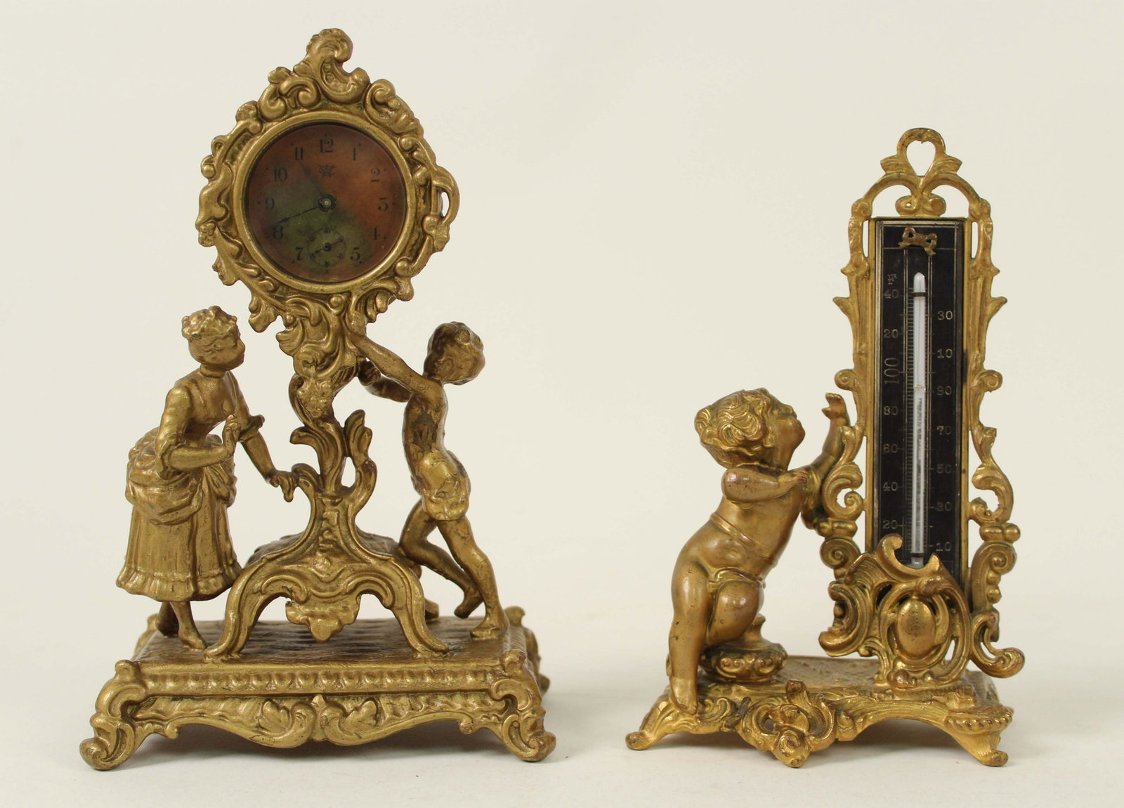 Waterberry Novelty Clock & Victorian Thermometer: Waterberry Novelty Clock & Victorian Thermometer. (1) Waterberry cast metal with gold gilt and painted surface novelty clock with lady and young girl. Measures 8 3/8" high. (1) Victorian cast metal wi