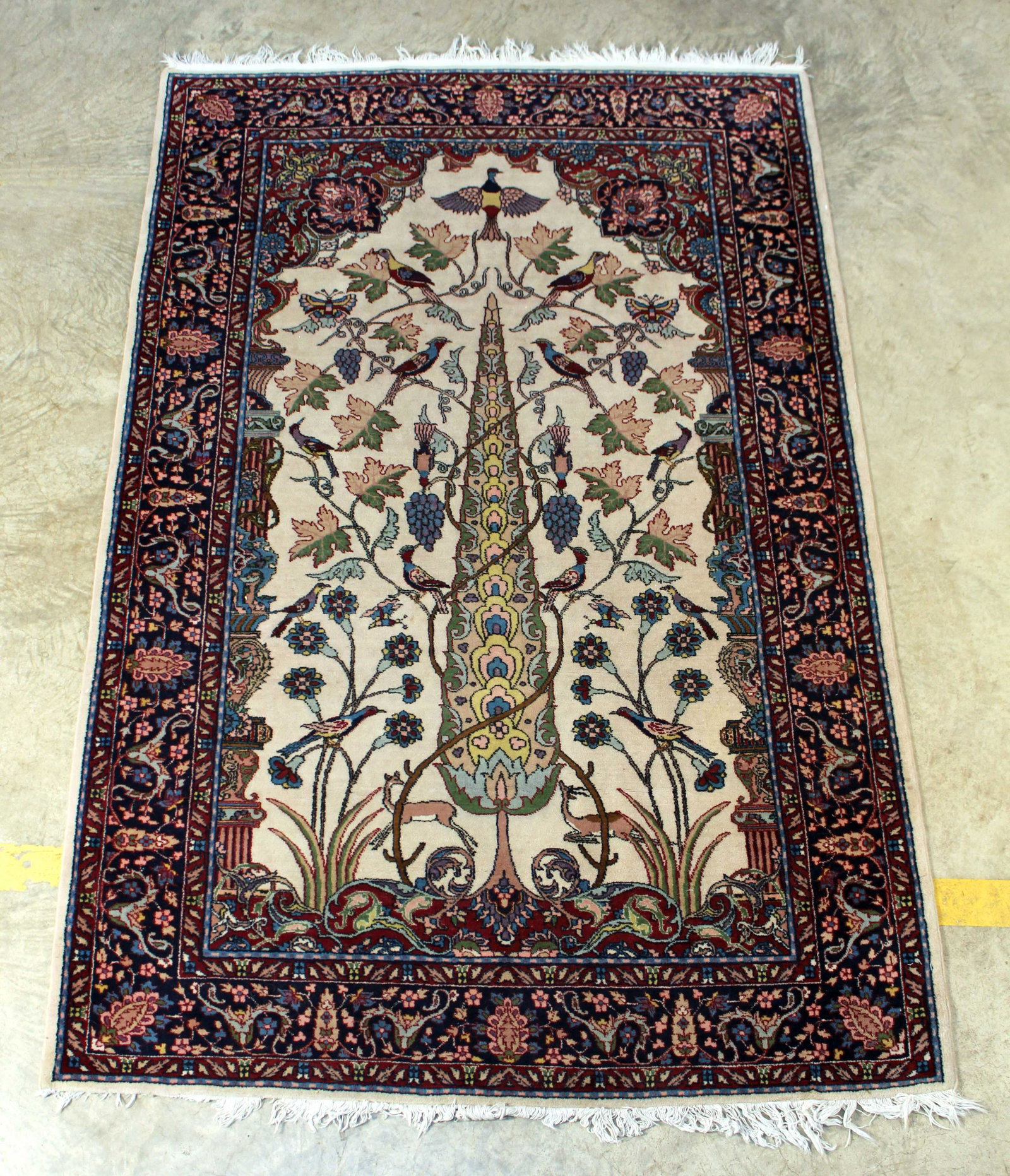 Persian Tree of Life Wool Rug: Persian Tree of Life Wool Rug. Cream center area with Tree of Life, birds, flowers and deer. The center portion of the rug is surrounded with multicolor decoration in blues, burgundy and pink. The rug