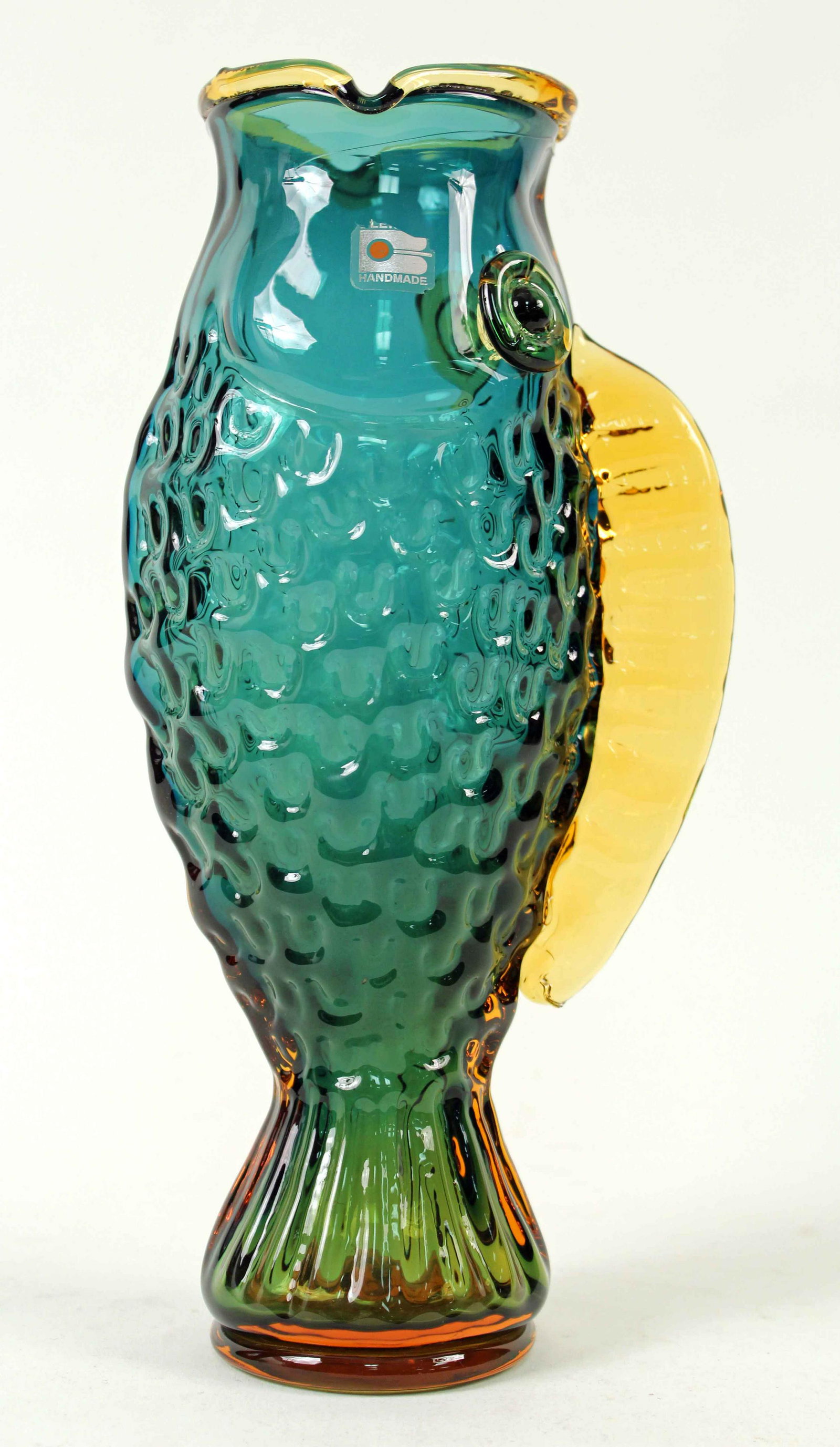Blenko Glass Teal & Amber Handmade Fish Vase: Blenko Glass #9425 Teal and Amber Handmade Fish Vase by Hank Adams (1999-2000). Measures 12" high. Has a partial label. Condition- Vase is in overall good condition. See photos.