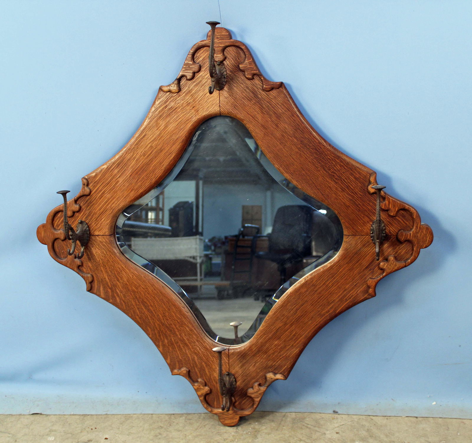 Circa 1900 Oak Hanging Halltree Mirror: Circa 1900 Oak Hanging Halltree Mirror. This piece has a beveled mirror and four decorative cast hat and coat hooks. The mirror measures 42" Square. Condition - The mirror is in good condition.