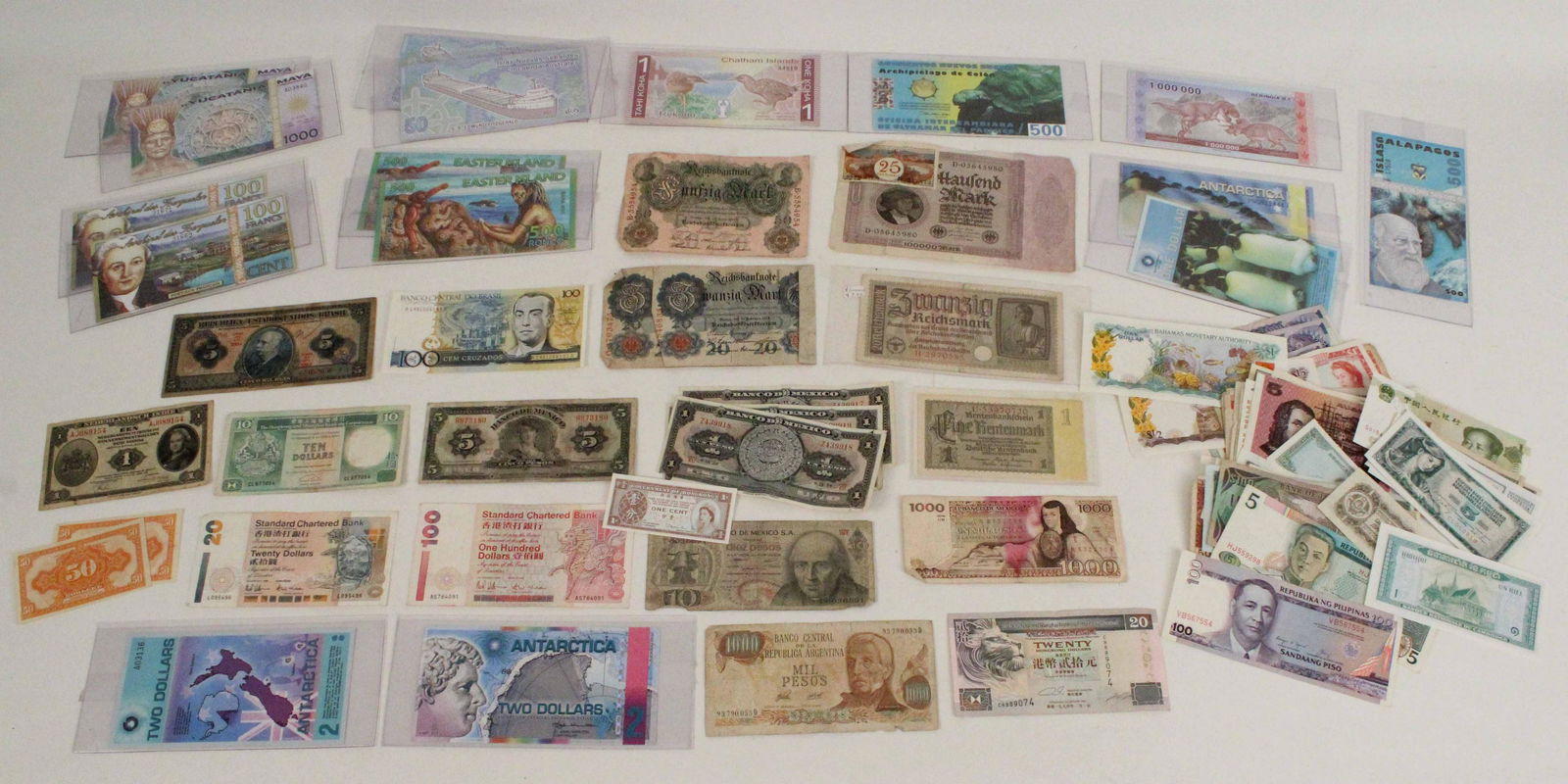 Large Group of World Currency: (6) Mexican currency bills, Un Mil Pesos. 1018 Pesos. Group of German bills, 1910-1930s. (1) 1994 Hong Kong Standard Charted Bank $100. (1) 1994 Hong China-Standard Chartered Bank $20. (1) 1990 Hong K