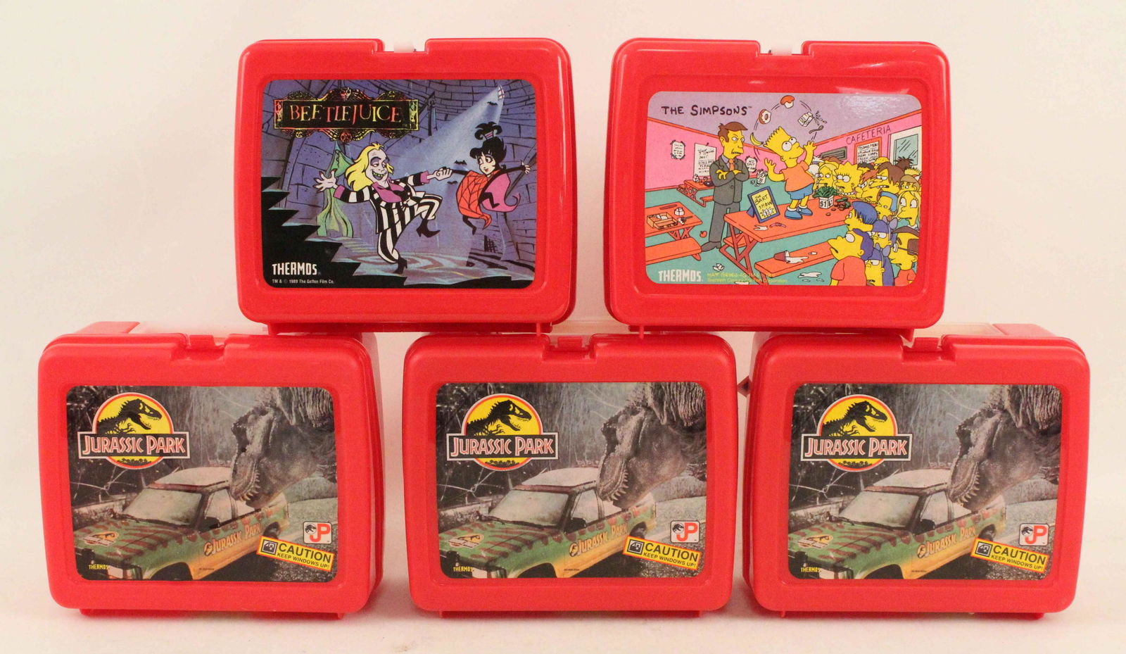 Five NOS Thermos Lunchboxes, Jurassic Park, Etc.: Five NOS Thermos Lunchboxes, Jurassic Park, Etc. (3) Jurassic Park lunchboxes with thermoses. (1) 1990 The Simpsons lunchbox with thermos. (1) 1989 Beetle Juice lunchbox with thermos. Condition- New o