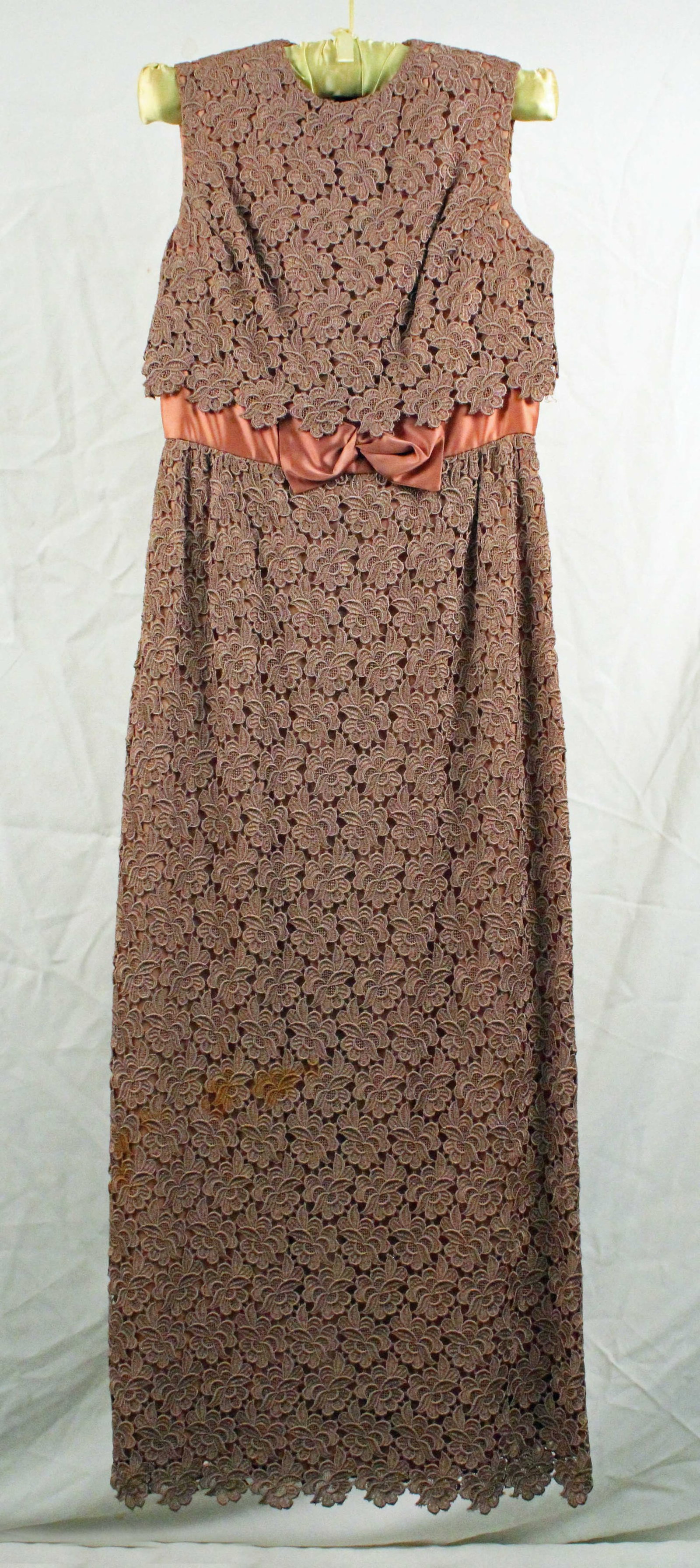 "Blanes" Toast Applique Lace Gown: Attributed "Blanes" Toast Applique Lace Gown. Beautiful toast colored floral pattern gown with empire waist and bronze colored satin midriff trim and front bow. The gown is fully lined. Labeled as a E