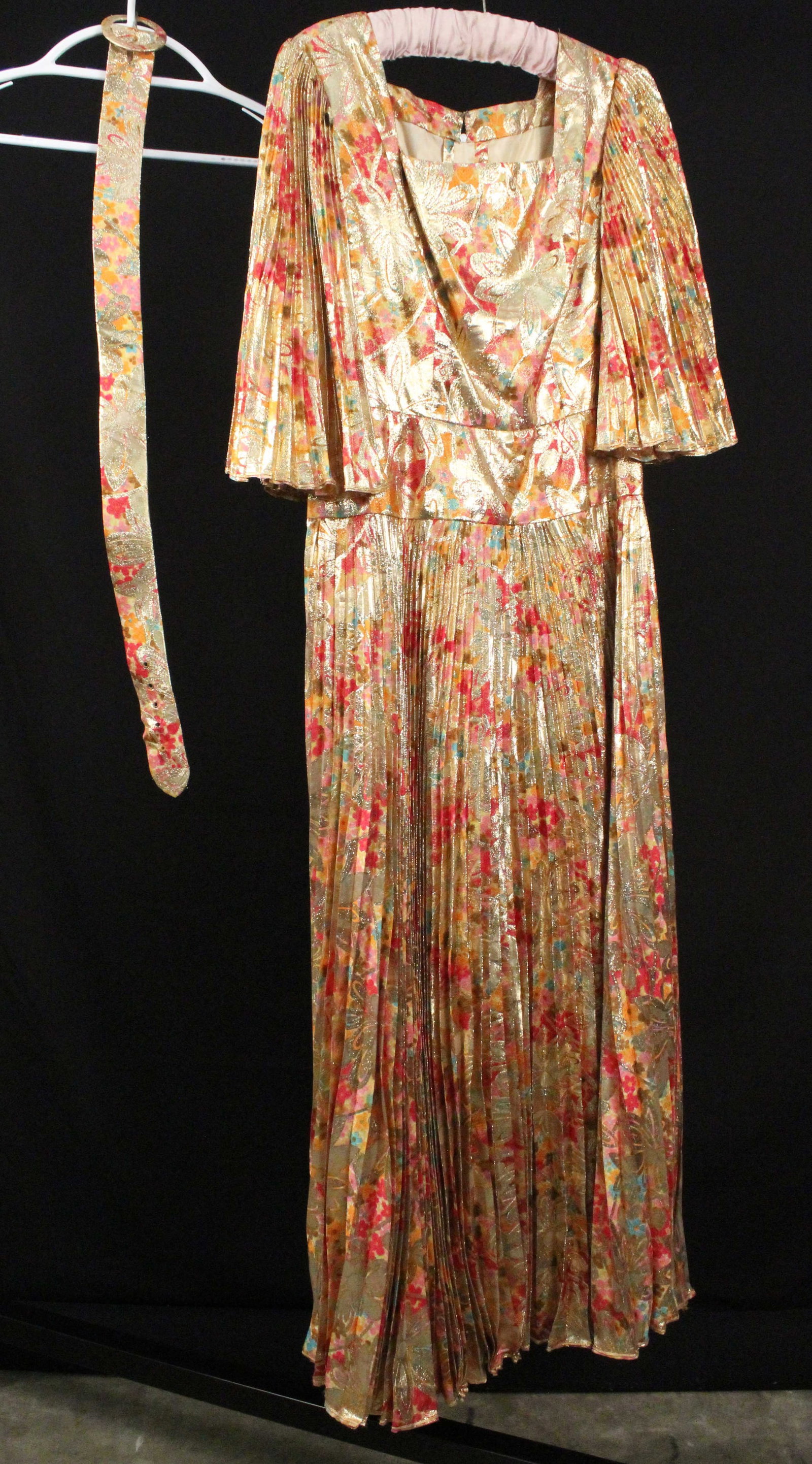 Gold-Multi Colored Floral Lame Gown: Gold-Multi Colored Floral Print Lame Gown with Square Neck. Nice fitted bodice with 3/4 length, knife pleated sleeve and skirt. Comes with matching belt. According to the family of the owner, most of 