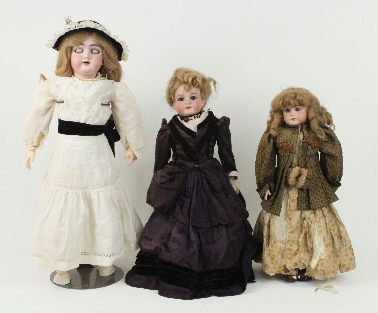 (3) German Bisque Dolls: (3) German Bisque Dolls. (1) 26" tall bisque doll with jointed composition body, open mouth, and sleep eyes. Marked with an "H 109 13 3/4." Believed to be a Heinrich Handwerck. Wearing a linen dress w