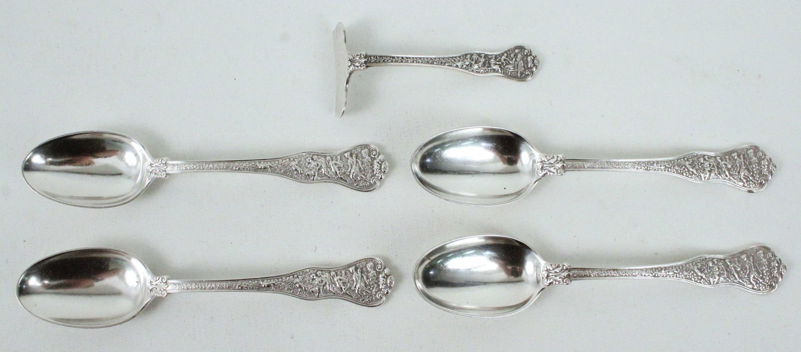 Tiffany Olympian Baby Food Pusher & Teaspoons: Tiffany Olympian Pattern Sterling Silver Baby Food Pusher and (4) Teaspoons, Solid, 1878. Decorated with Grecian scenes, Bacchus masks, and cupids. All pieces are marked, "Tiffany & Co. Sterling Pat. 