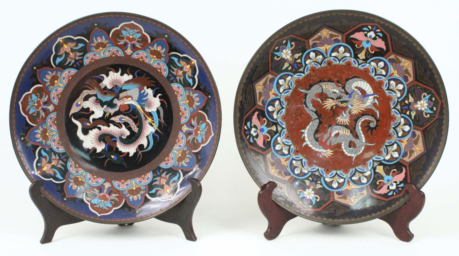 (2) Antique Japanese Cloisonne Chargers: (2) Antique Japanese Cloisonne Chargers with Dragon and Phoenix Decoration. Measure approximately 12" diameter X 1 1/2" high. Condition- Very good condition with some wear. Both have chips on rim at t