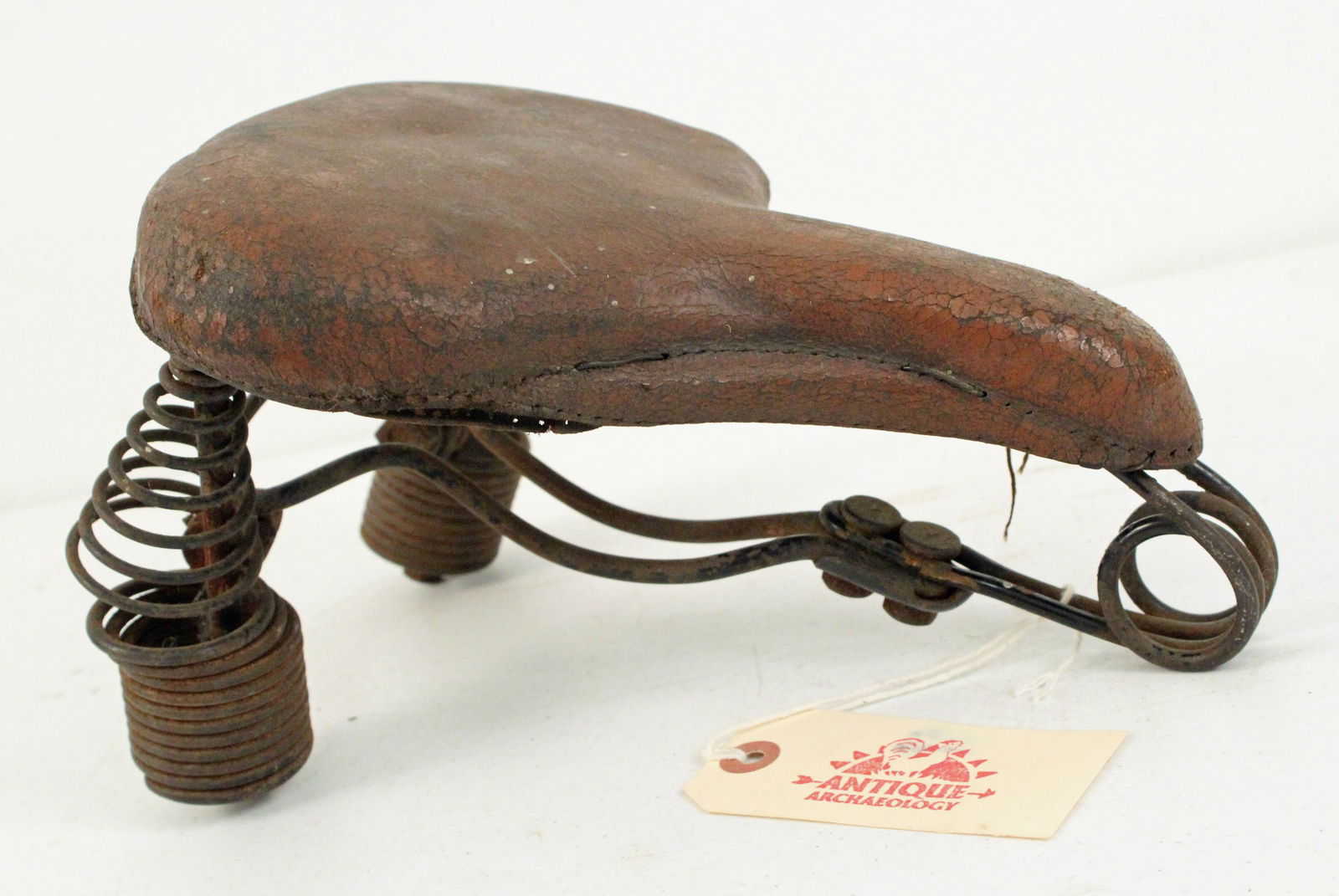 Vintage Leather Covered Bicycle Seat: Vintage Leather Covered Bicycle Seat with Long Springs. Measures 6 1/2" high X 8" wide X 12" long. Provenance the remaining inventory of Antique Archaeology, closed Nashville, Tennessee location.