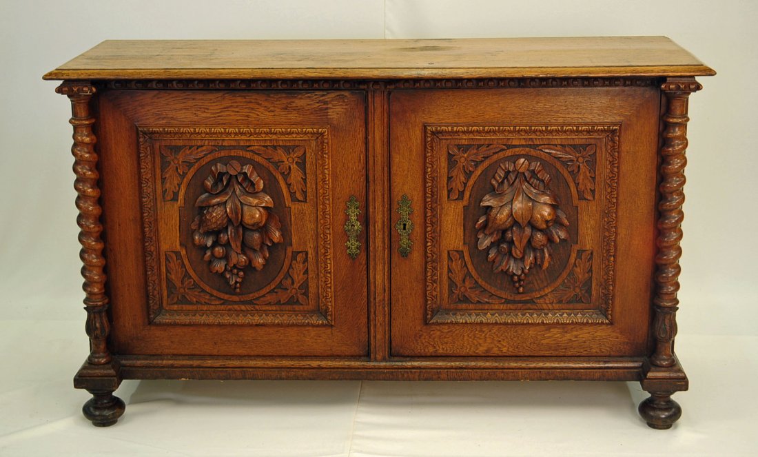 French Renaissance Revival Oak Buffet: French renaissance revival oak buffet. Doors with high relief fruit carving and barley twist columns. Front turned bun feet. Bas-relief carvings give the impression of arches. Third quarter nineteenth