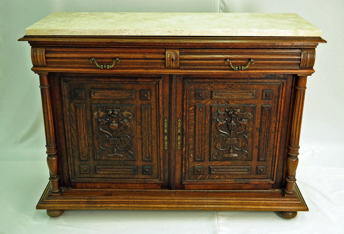 Carved Oak French Renaissance Marble Top Buffet: Carved oak French renaissance marble top buffet. Heavy carved doors flanked by fluted and turned columns, below two drawers. Large base molding above bun feet. Measures 39.25" H. X 55" W. X 21" D.