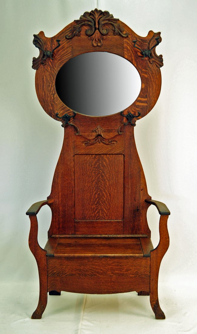 American Quartered Oak Hall Tree with Oval Mirror: American quartered oak hall tree with oval mirror and four coat hooks. Lift seat. Measures - 81" H. X 36" W. X 16" D.