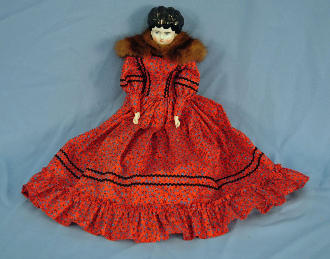 14.5" China Head Doll In Red Print Cotton Dress: 14.5" China Head And Shoulder Doll In Red Print Cotton Dress. Doll has black hair, 1880's hair style, blue eyes, cloth body, mink collar, and red print cotton dress.
