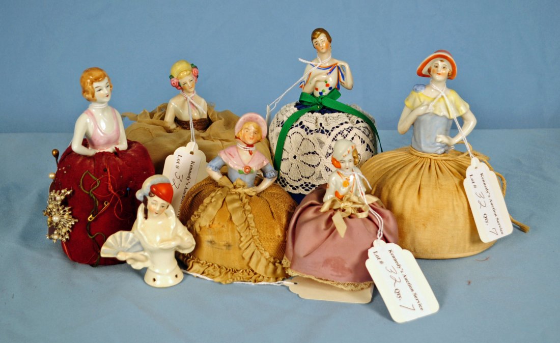 Seven Half Doll Porcelain Pin Cushions: Seven Half Doll Porcelain Pin Cushions. Heights vary from 3.5" to 7.5" One is half doll only, no pin cushion. One doll marked Germany. Condition - cushions in various conditions from poor to good, one