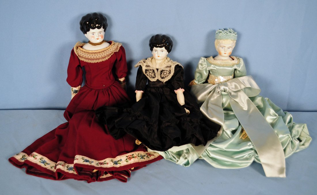 2 China Head Dolls & 1 Parian Doll: 2 China Head Dolls & 1 Parian Doll Includes: 17.5" China Head doll in purple dress with blue eyes and cloth body. 13.25" China Head doll in black taffeta with blue eyes and cloth body. 13" Parian Doll