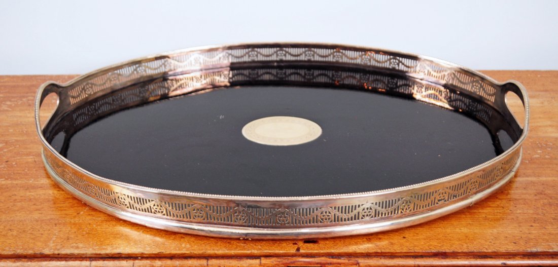 Large Oval Serving Tray w/ Reticulated Gallery: Large oval silver plate serving tray with reticulated gallery, ebonized wood tray surface and inlaid center silver medallion. Dimensions are approx. 16"W x 24"L. - Condition: Good condition, band has 