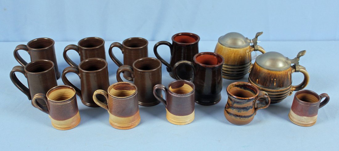 13 Stoneware Pottery Cups and 2 German Steins: 13 Stoneware Pottery Cups and 2 German Steins.(2) S.J. Pottery Bethel Missouri Redware 4.5" High. (6) Brown glaze with seated dog mark 4" high. (2) Half Liter German steins with pewter lids 5" high. (