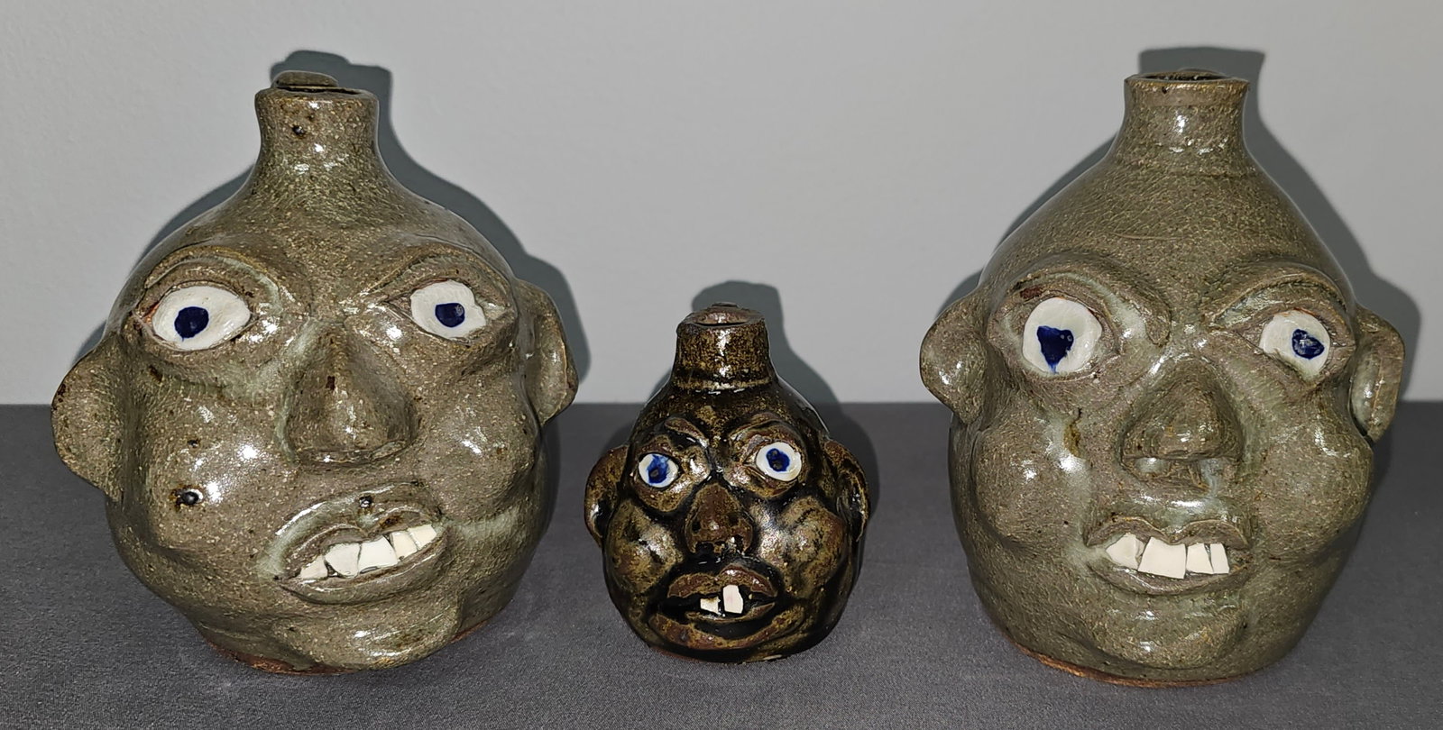 Grace Nell Hewell Face Jug Lot of 3: Grace Nell Hewell Face Jug Lot of 3 1 - Pair of Twins mini face jugs both are mint and dated 6-2-1998 and have a great folky look that was classic to Grace work. 2- mini face jug with china plate teet