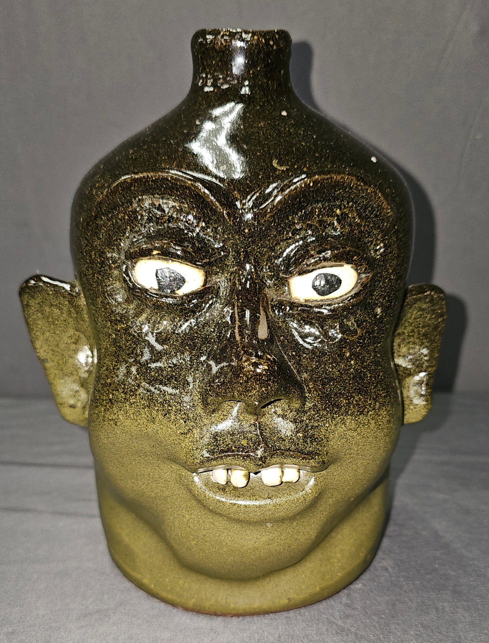 Fine Lanier Meaders Face Jug 1970s: Fine Lanier Meaders Face Jug that has a very unique look and is one of the more sought after face jugs by Lanier. Circa 1977. This one is a very nice two toned alkaline glaze with only one row of clay