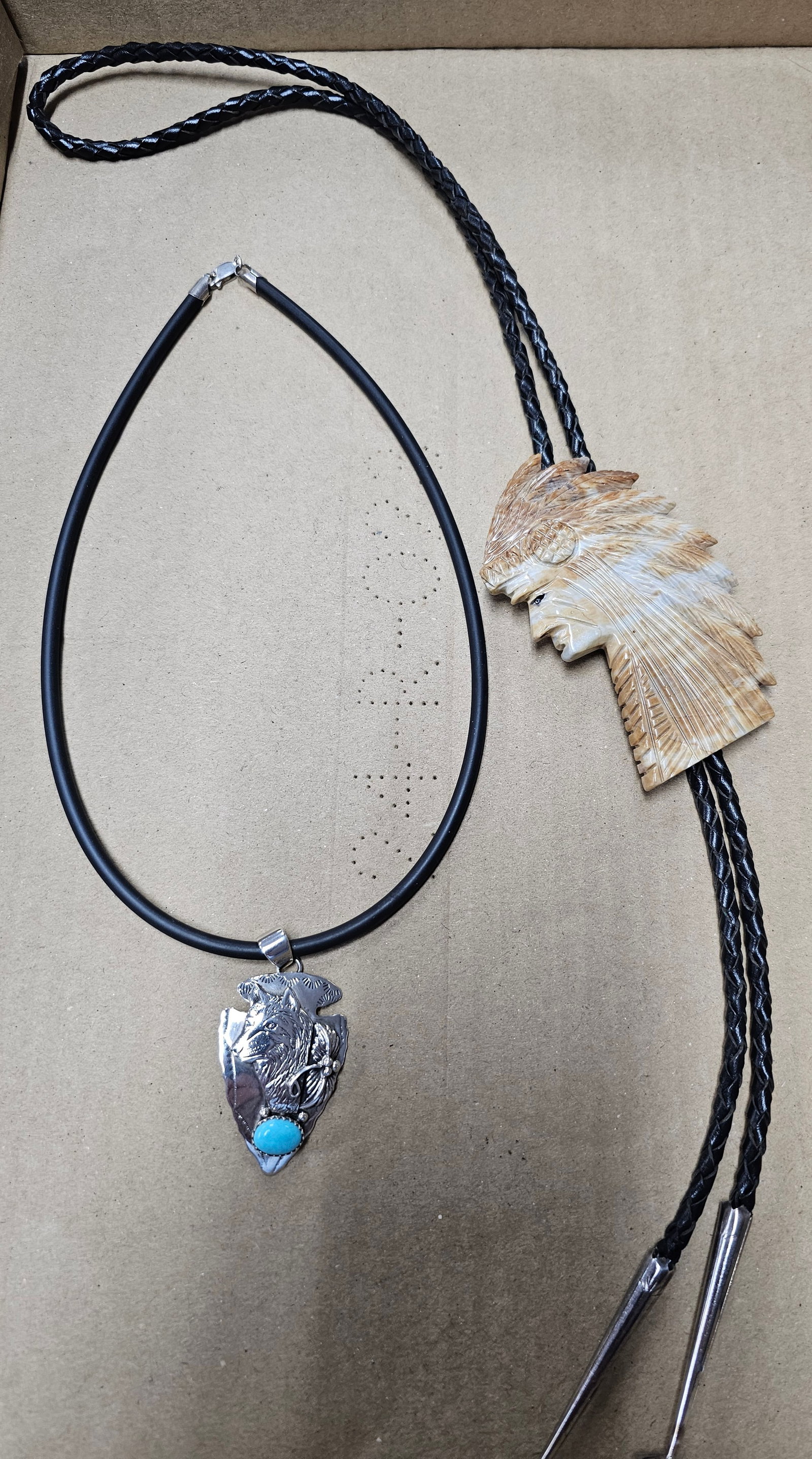 Navajo Sterling Silver Native American Jewelry Lot: Navajo Sterling Silver Native American Jewelry Lot, both examples are in collector grade condition, Sterling Arrowhead with Wolf signed JJ, weight: 14grams 2- Picasso Marble Indian Chief Bolo Tie.