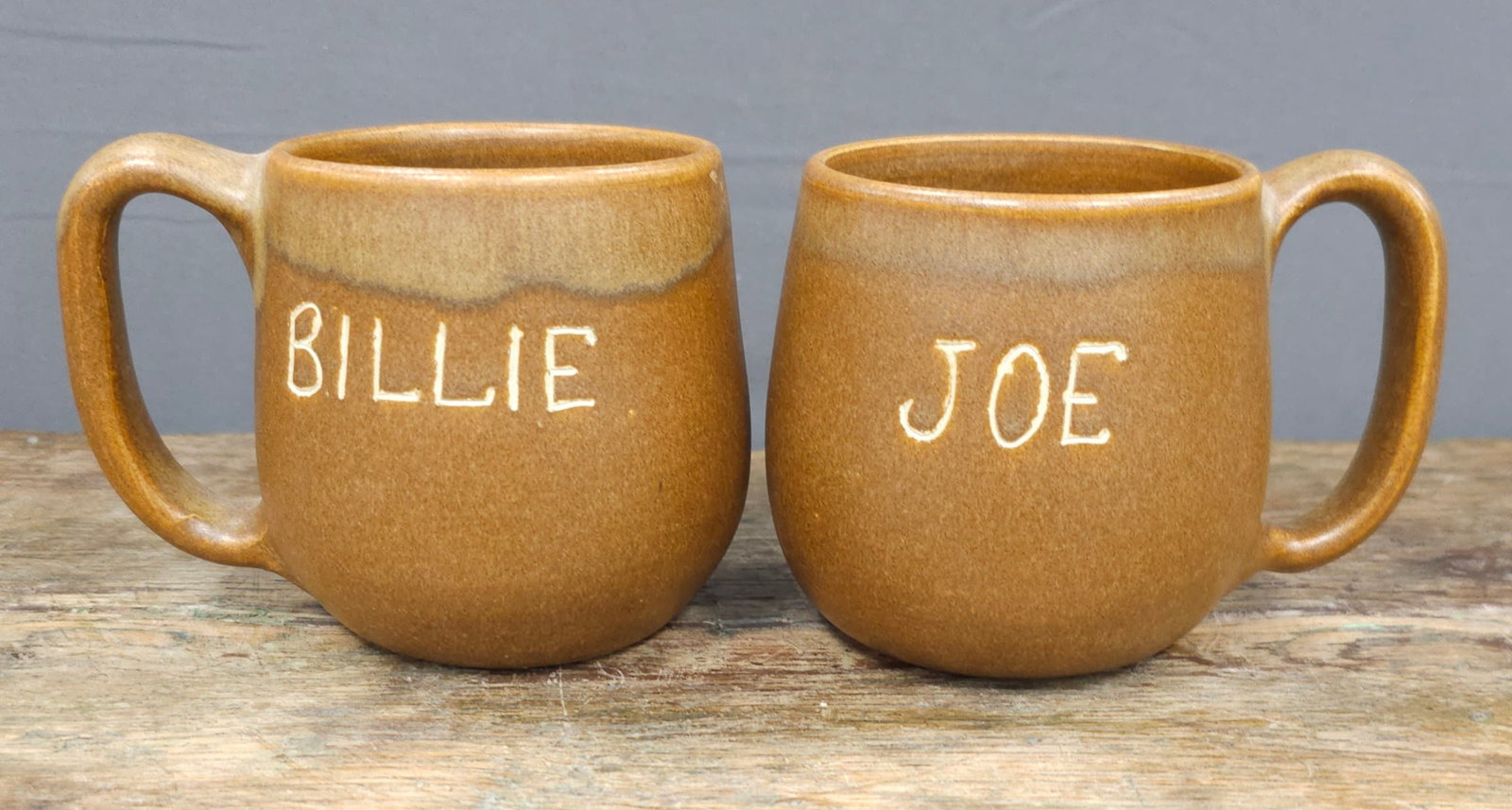 WJ "Bill" Gordy Joe & Billie Coffe Mugs: WJ "Bill" Gordy Joe & Billie Coffe Mugs, in Mountian Gold glaze. Signed and both are in collector grade mint condition. Standing: 3 3/8" Tall Each.