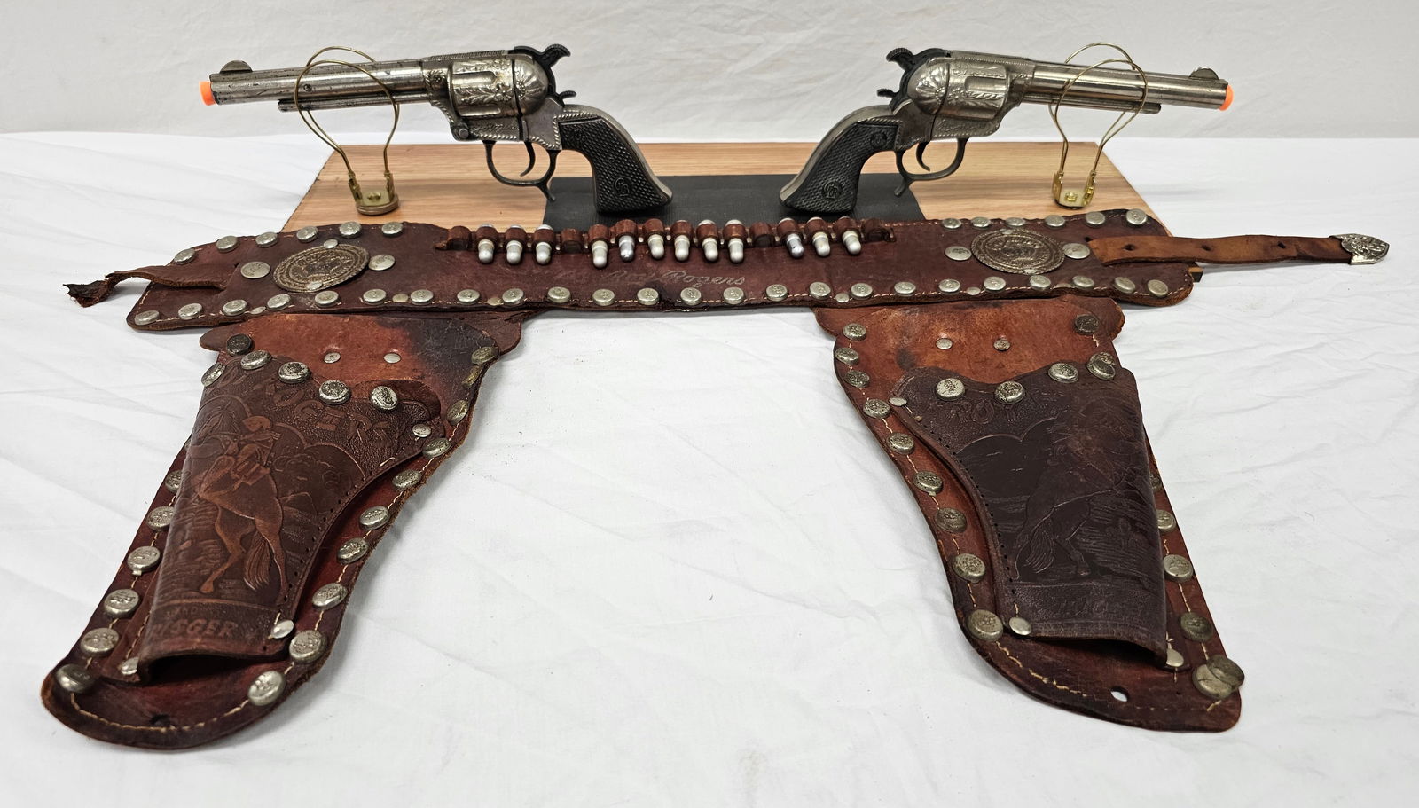Roy Rogers 2 Gun Holster Cap Gun Set By Schmidt: Roy Rogers Two Gun Holster Cap Gun Set By Schmidt in collector grade condition. Holster is in great condition. Belt Buckle has damage and can be fixed by a leatherman. See pictures.