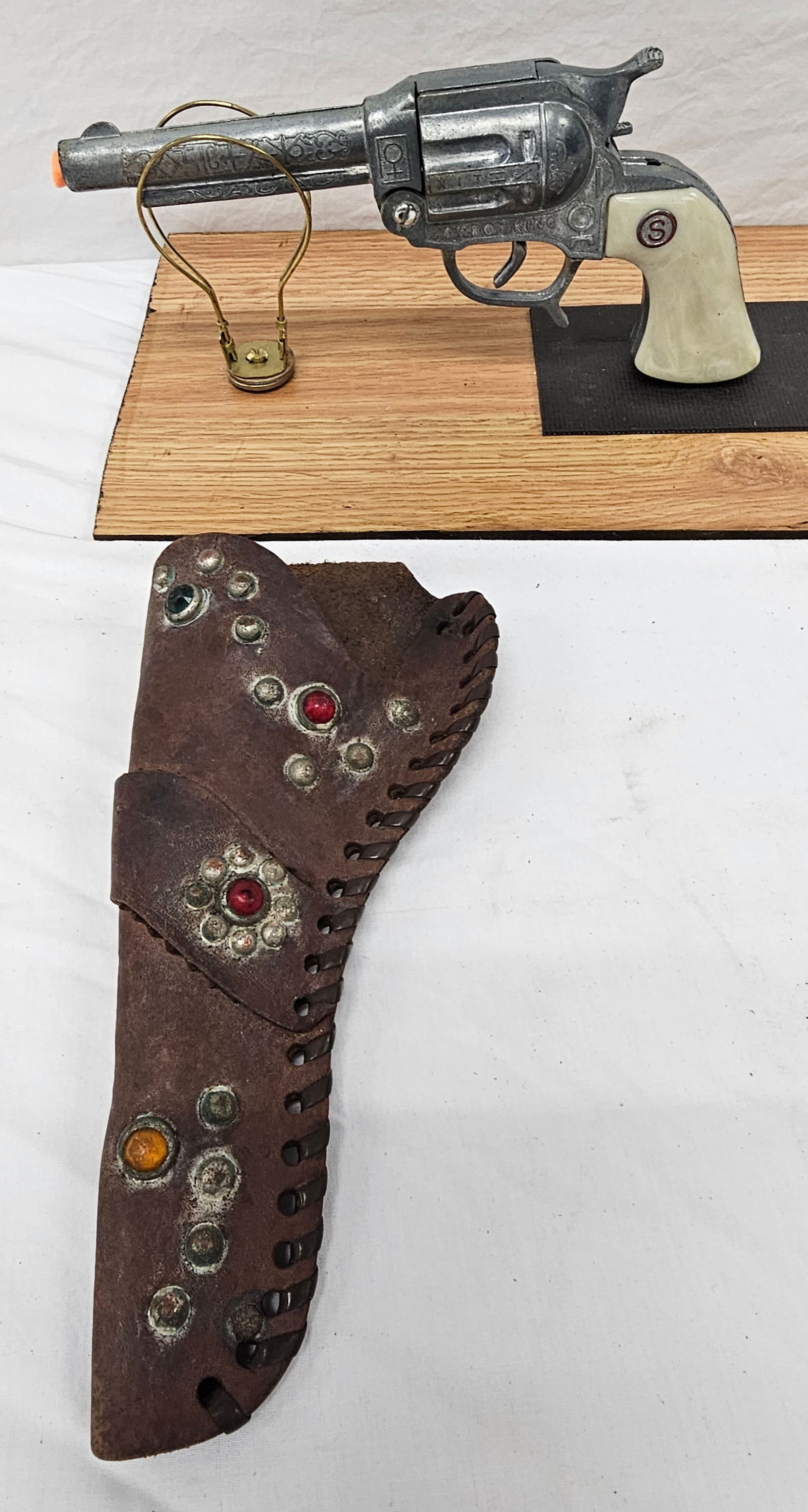 Cowboy King Stevens Cap Gun W/Jeweled Holster NOS: A outstnding 1950-1955 Cowboy King By Stevens Cap Gun With Jeweled Holster and the Gun is new old Stock. The Holster is in VG condition and has no belt. Collector grade example.