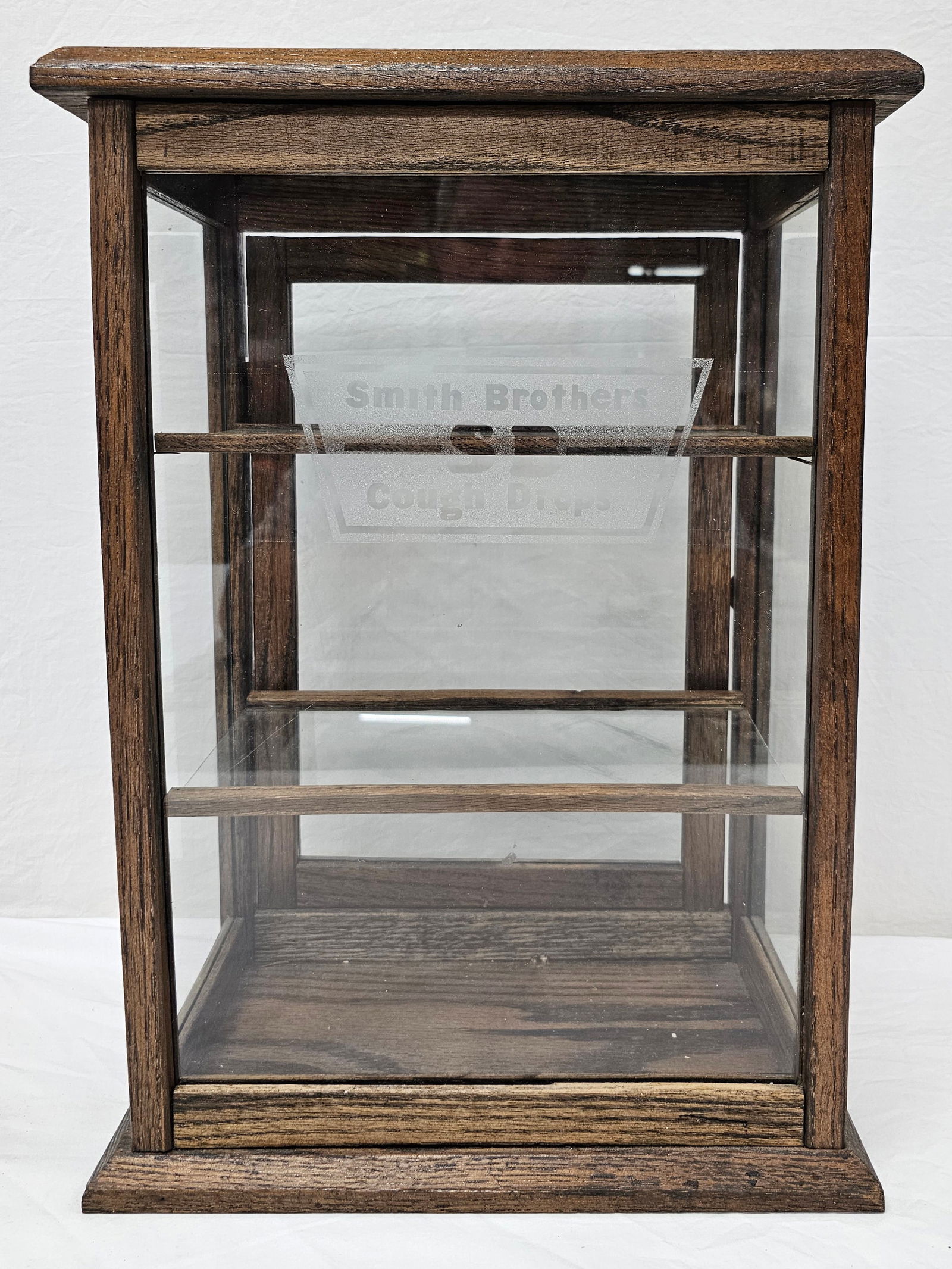Smith Bros. Cough Drops Small Oak Display Cabinet: Rare and fine Smith Brothers Cough Drops Small Oak Display Cabinet in Excellent condition. Has two original glass shelves. Collector grade example. Size: 19 1/2" T x 13" W x 7 1/2" D