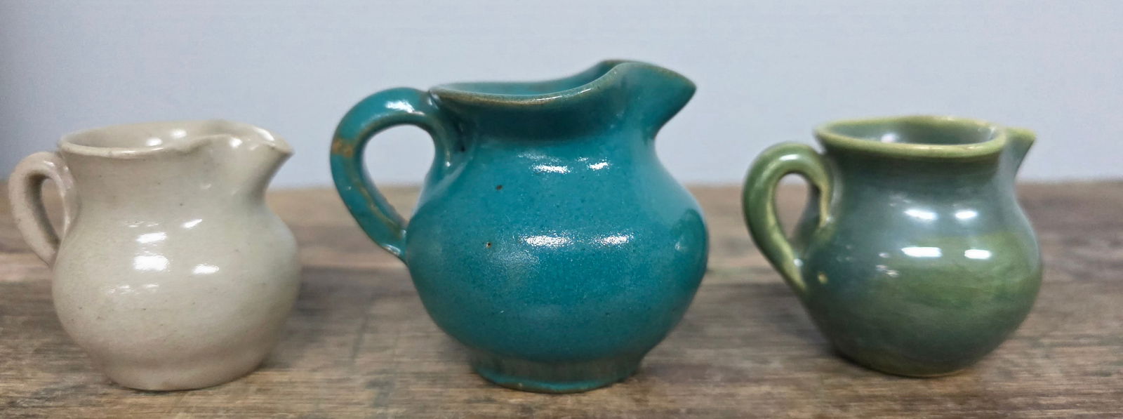 Small Pitcher Lot of 3: Small Pitcher Lot of 3. 1-Standing 1 3/4" tall stamped Georgia "GA" on the bottom. 2-Standing 1 3/4" tall and stamped Georgia Art Pottery on the bottom, has two tiny rim glaze flakes. 3-Standing 2 1/4