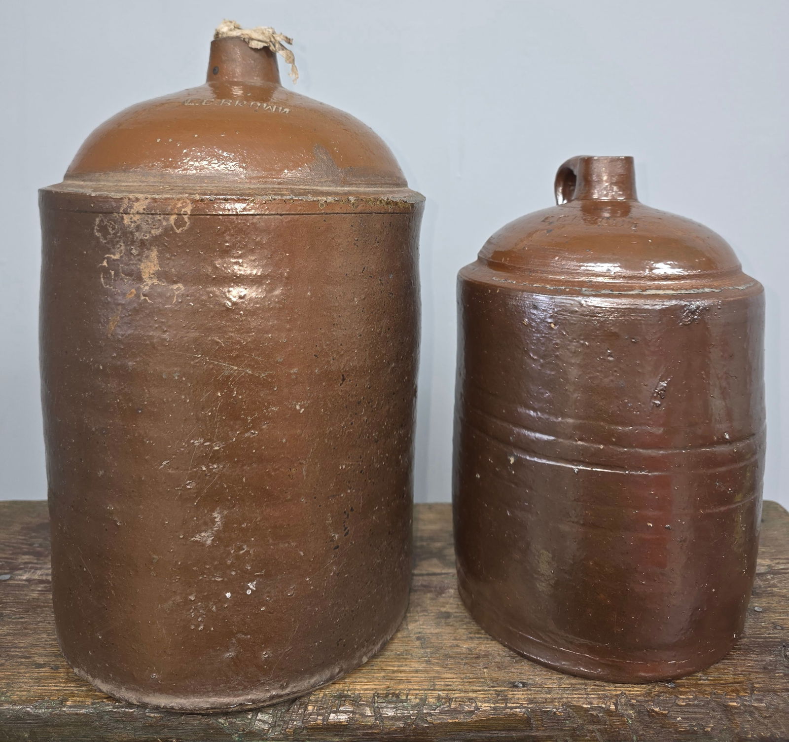 Signed EC Brown Jug Lot of 2: Signed E.C. Brown (1873-1944) jug lot of two. These are 1890s-1900s time period slip glaze jugs. Both examples bear a strong stamp on the shoulder. The jugs are one and two gallon sizes in collector g