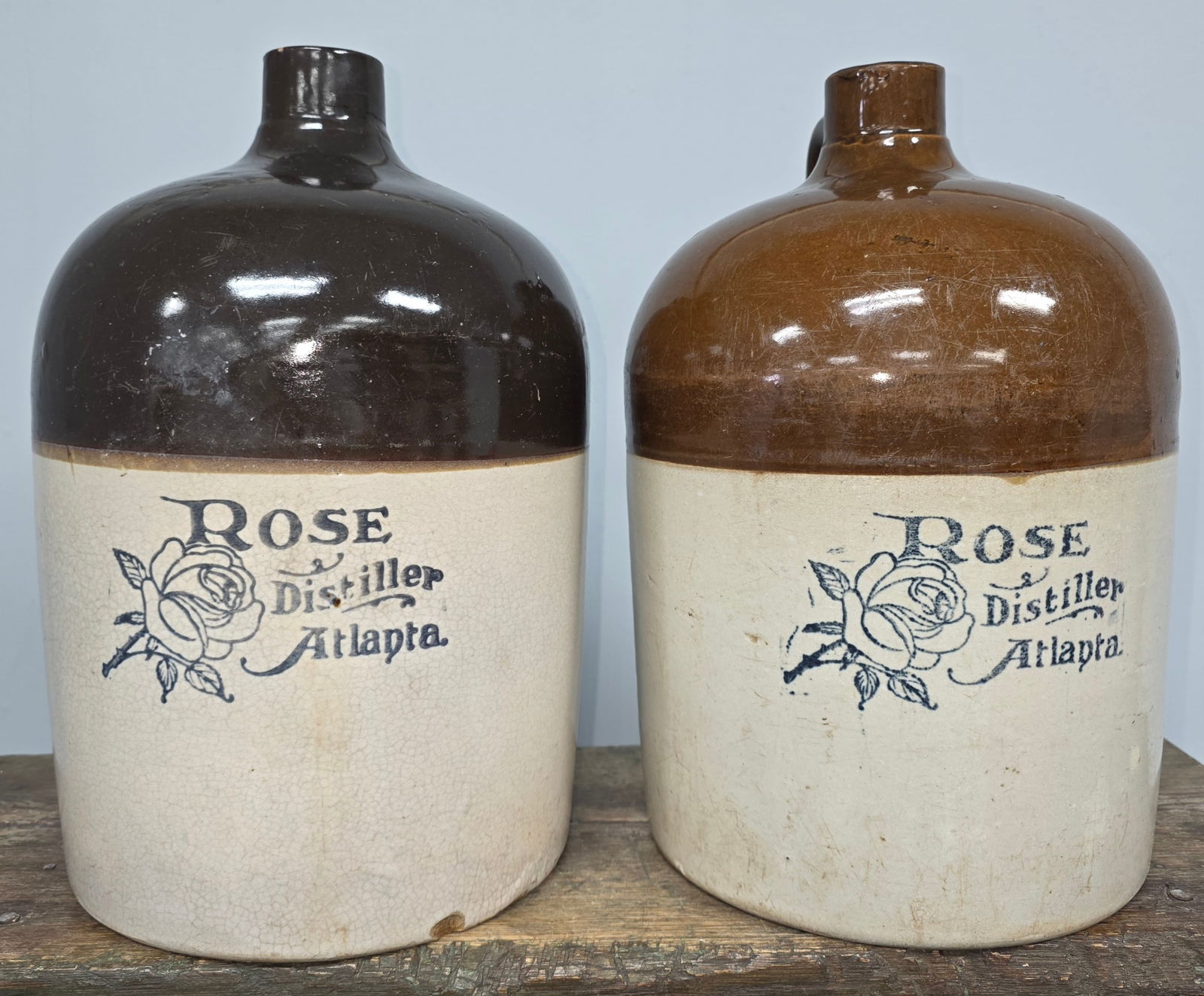R.M. Rose Distiller Atlanta Stencil Jug Lot of 2: R.M. Rose Distiller Atlanta Advertising Stencil Jug Lot of two. 1-Salt-glaze with a dark chocolate brown slip colored glaze top and R.M. Rose Distiller Atlanta stencil in light black. Chip on the rim
