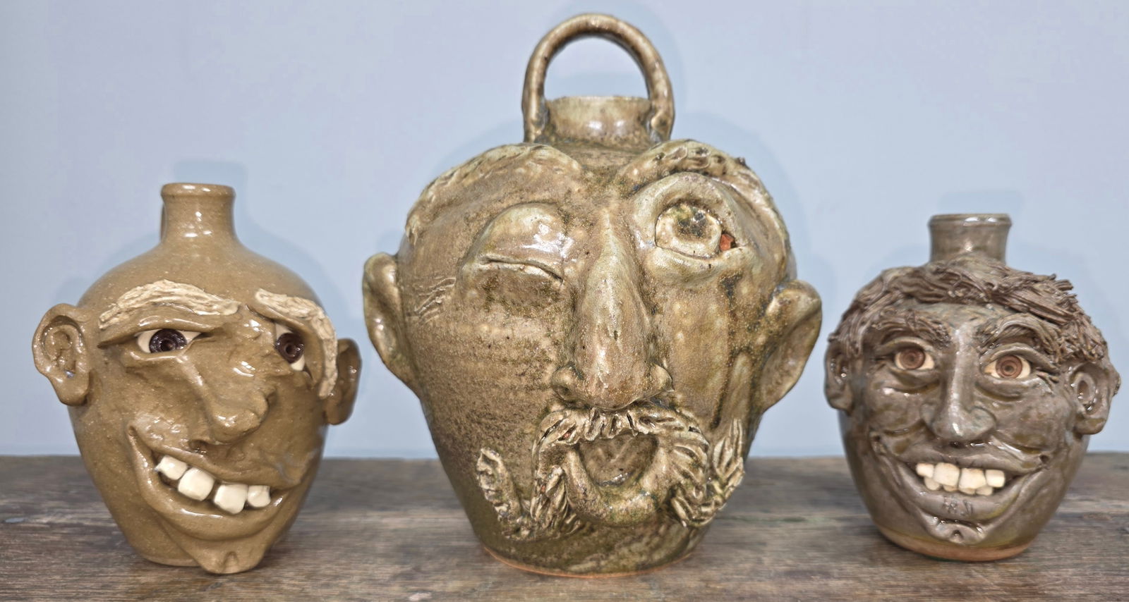 Folk Pottery Face jug Lot of Three: Folk Pottery Face jug Lot of Three all are in collector grade condition, no damage. Vikki Miller Ram Pottery jug. Standing: 8" Tall Cole Pottery Face Jug, Seagrove, NC. Standing: 5" Tall Cole Pottery