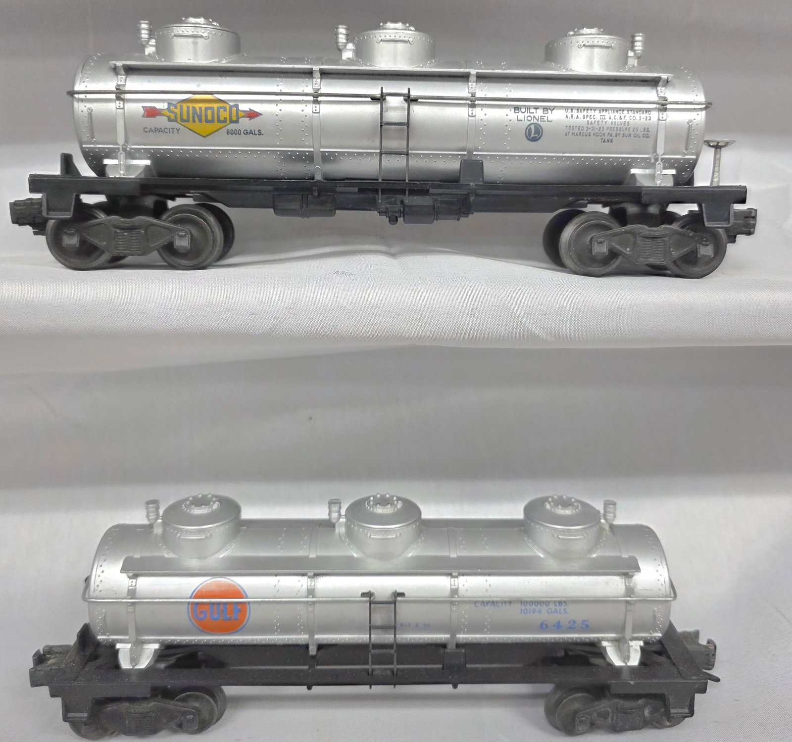 Lionel Postwar 6425 & 6415 Tank Car Lot of 2: Lionel Postwar 6425 & 6415 Tank Car Lot of 2. 1-6425 Gulf Oil Tank Car in C-7 condition. 2-6415 Sunoco 3 Dome Tank Car in C-7 condition.