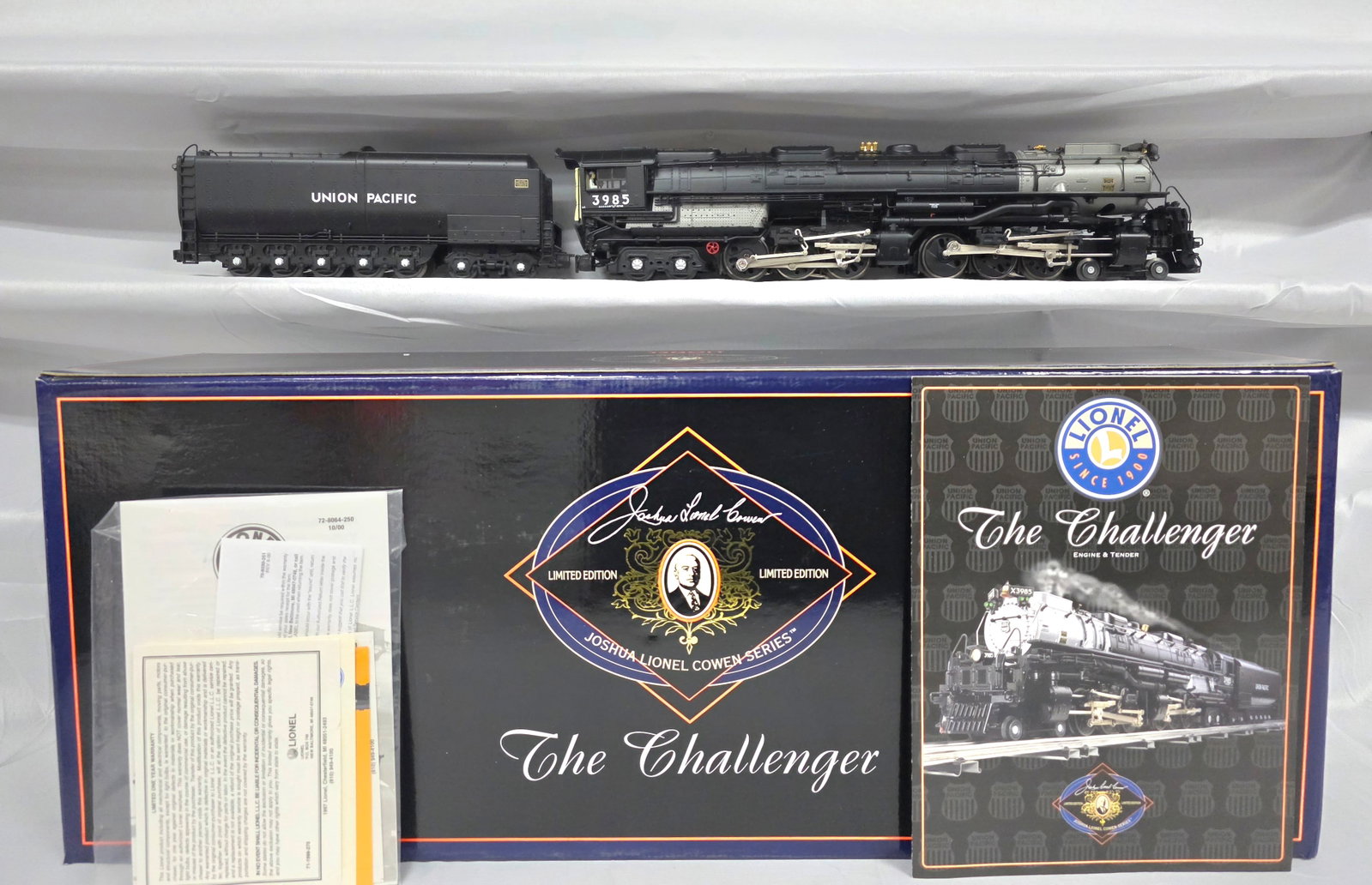 Lionel JLC Series Challenger W/Tender: A Lionel 6-28064 model train featuring a Union Pacific Challenger locomotive and its tender. The locomotive is primarily black with a silver/light grey boiler section and metallic accents. It is mark